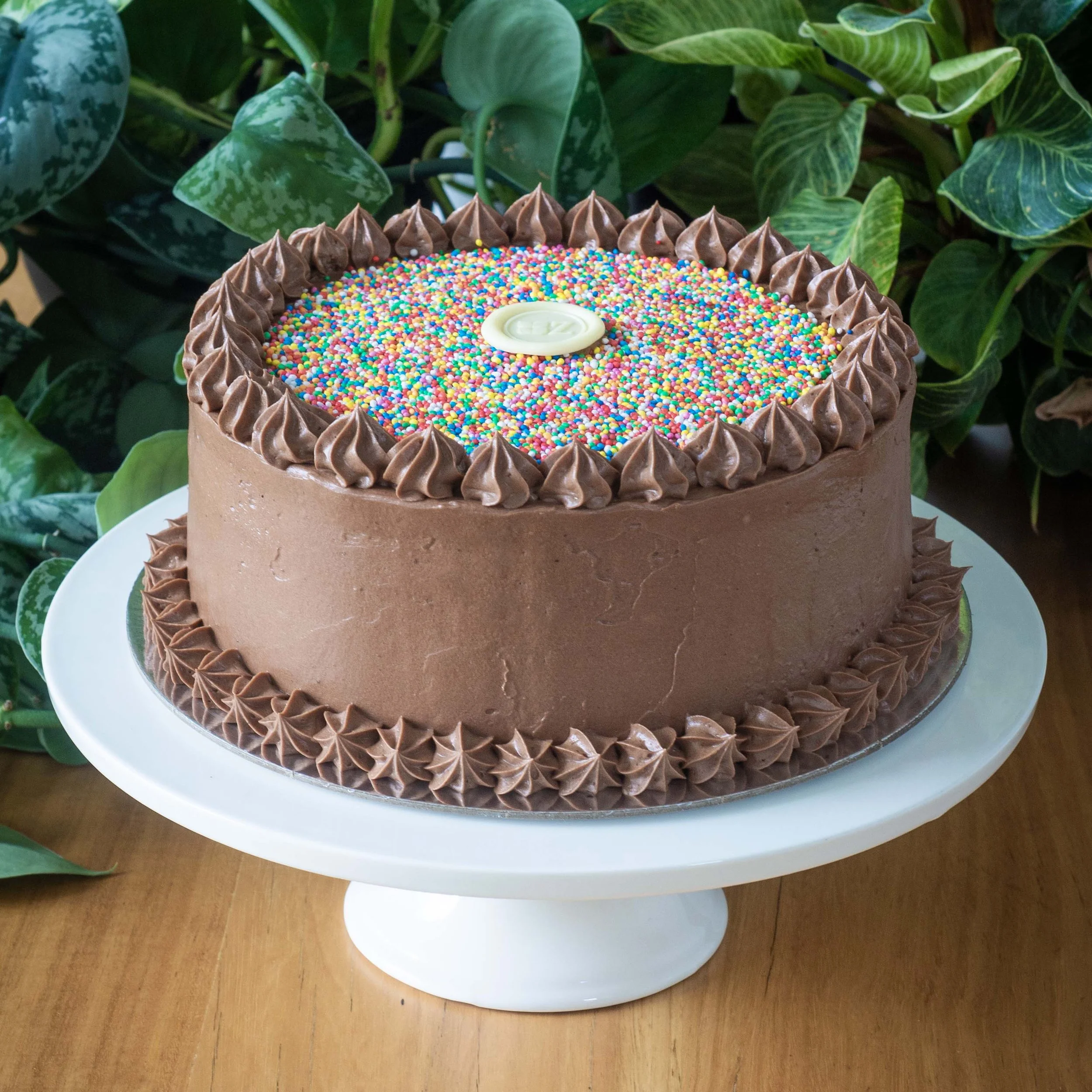 a colourful chocolate birthday cake with 100s and 1000s sprinkles on top