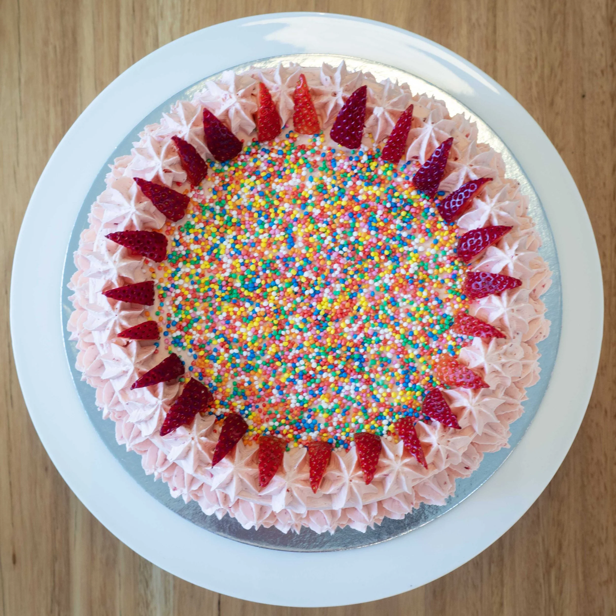 a view from above of a strawberry cake with sprinkles perfect for kids birthday parties