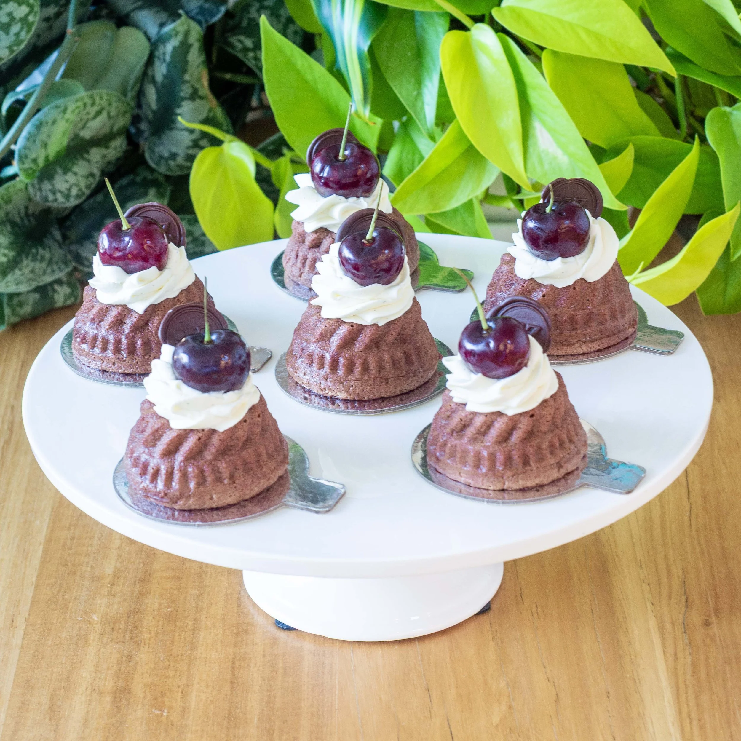 six Schwarzwälder Kirschtorte or Black Forest petits gateaux with cherries on a cake stand