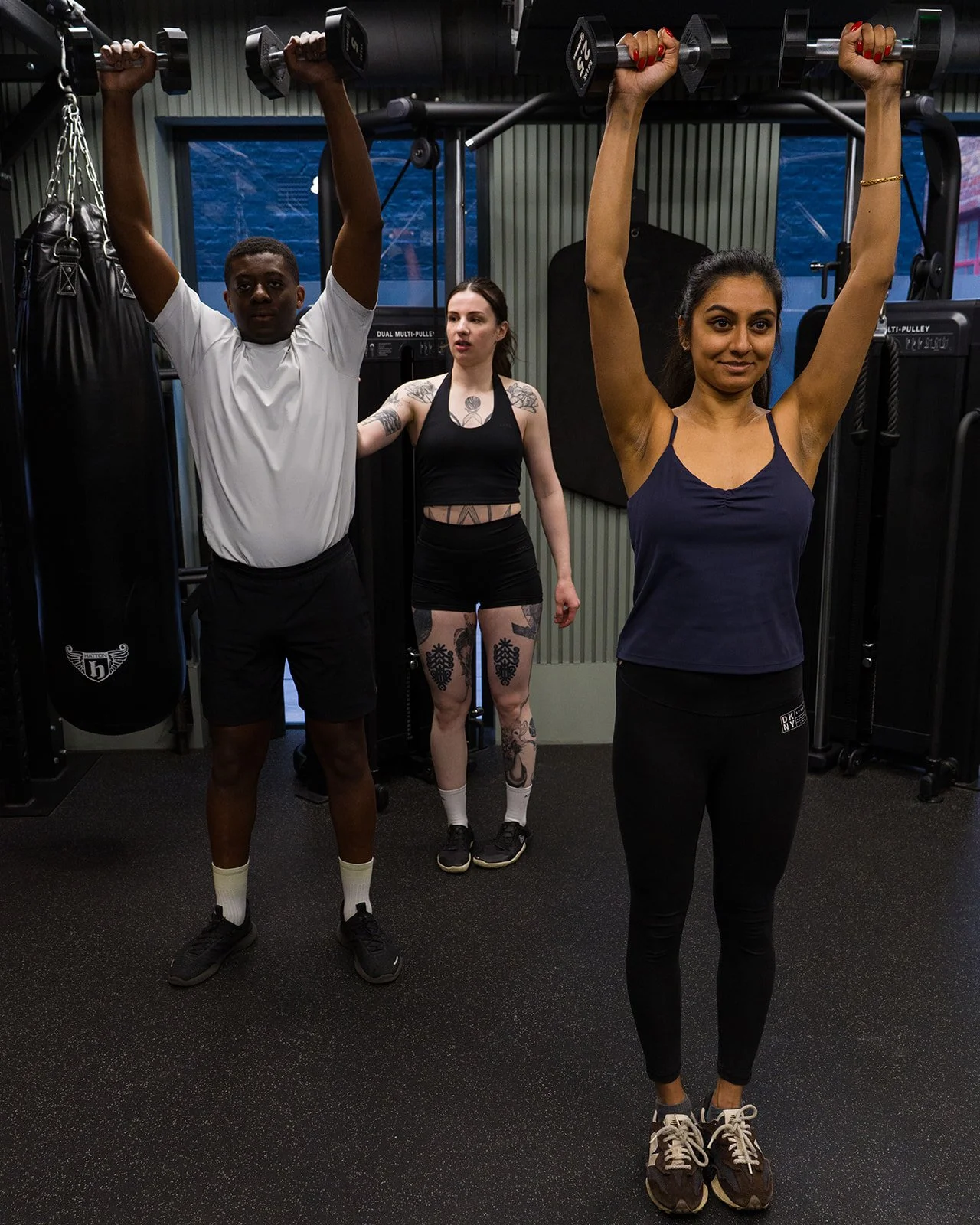Nicolina coaching a client on the correct form for a dumbbell upper body exercise
