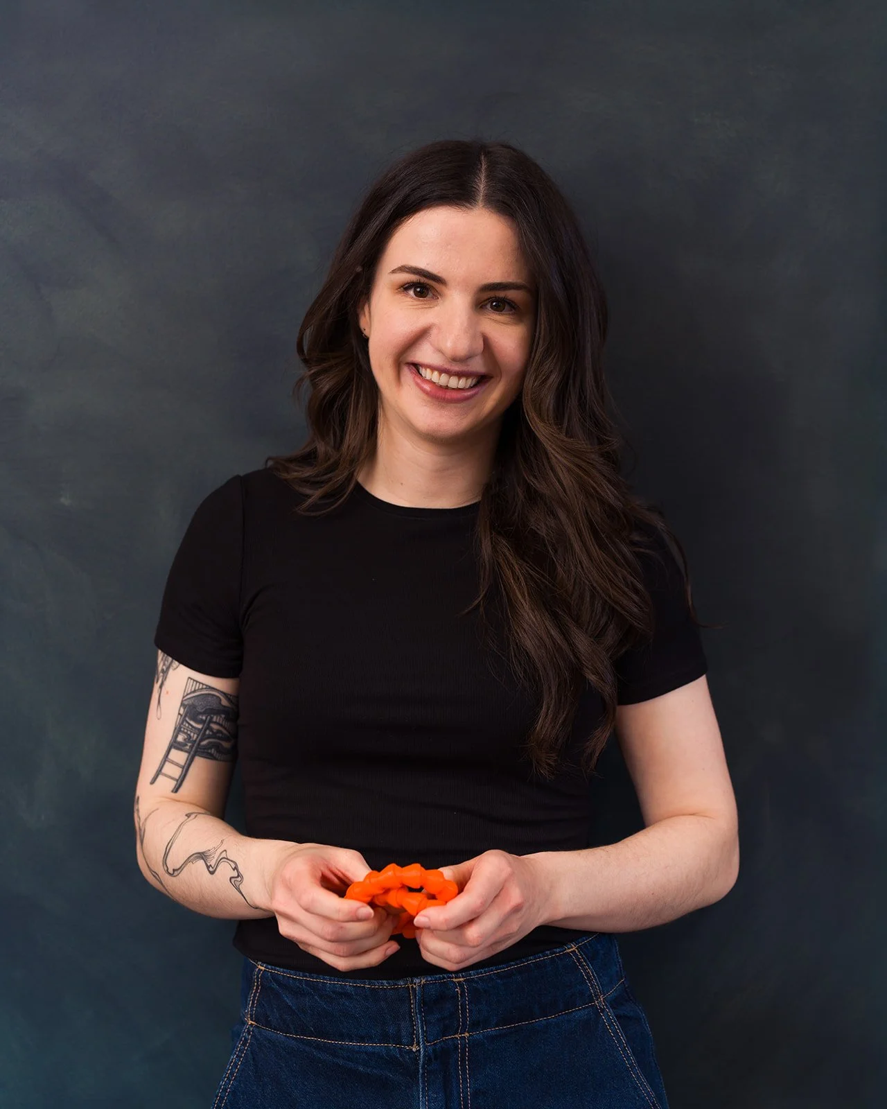 Nicolina smiling at the camera while playing with a fidget toy