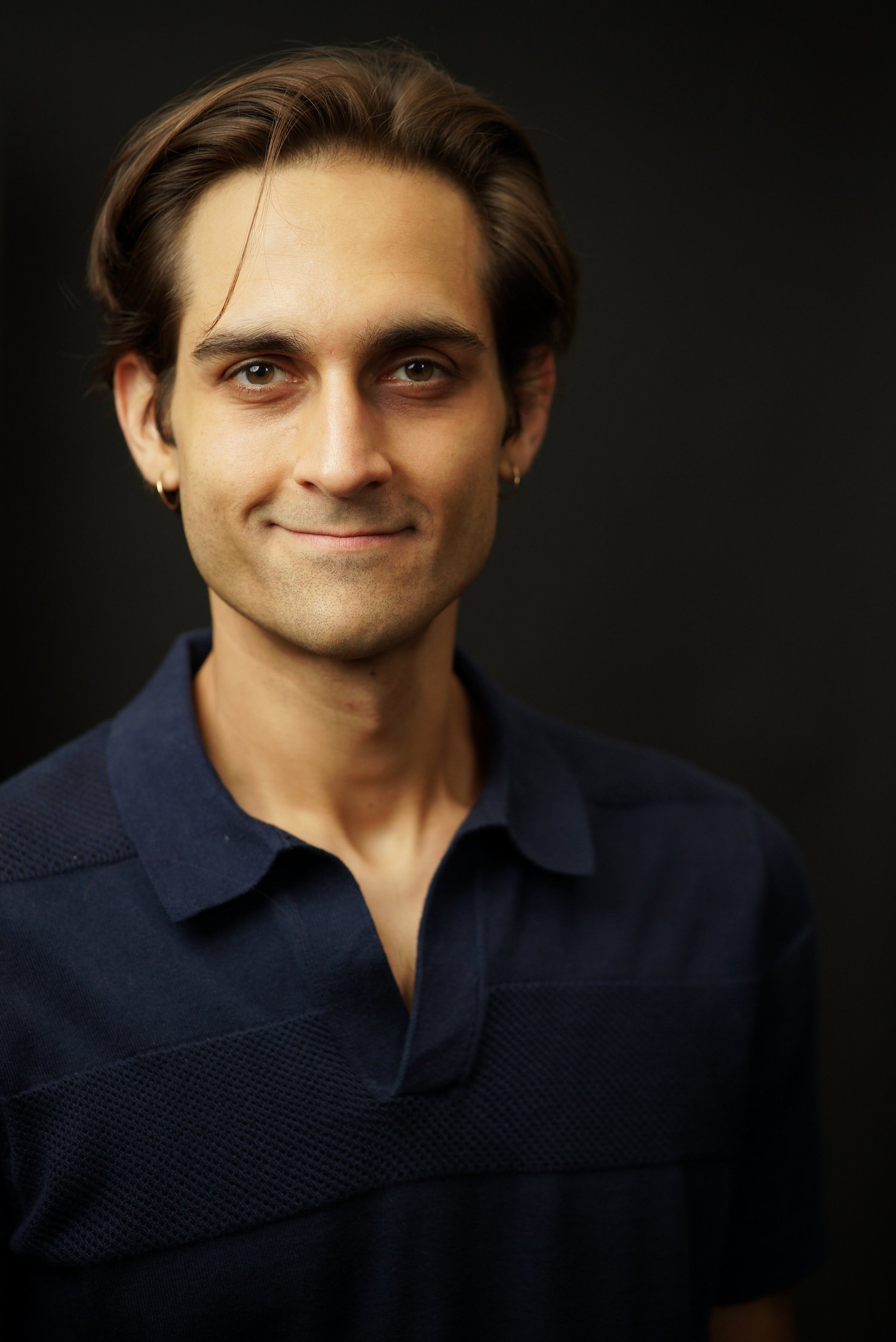Milan Babi primary actor headshot in navy polo, no glasses, no mustache
