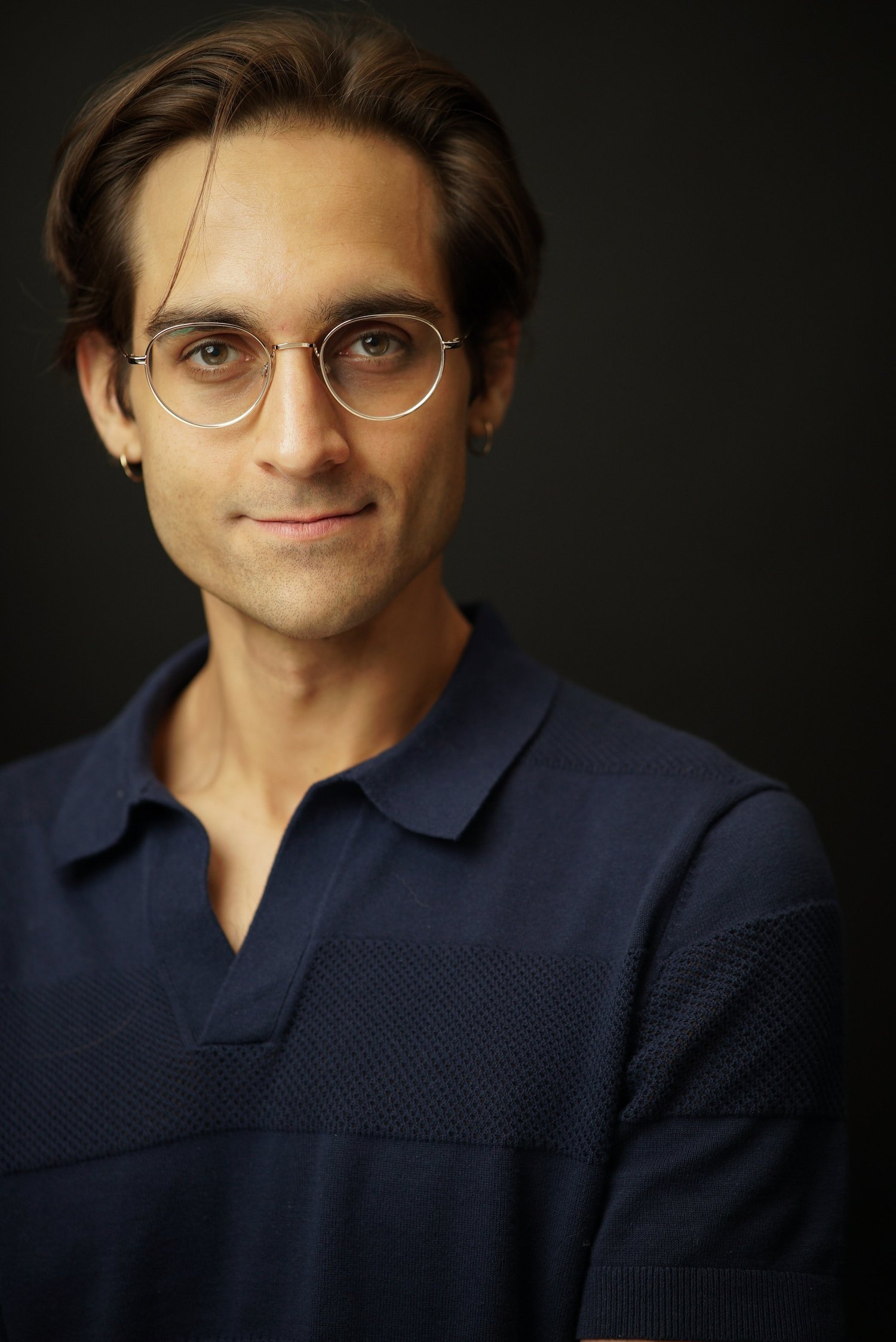 Milan Babi actor headshot with glasses in navy polo