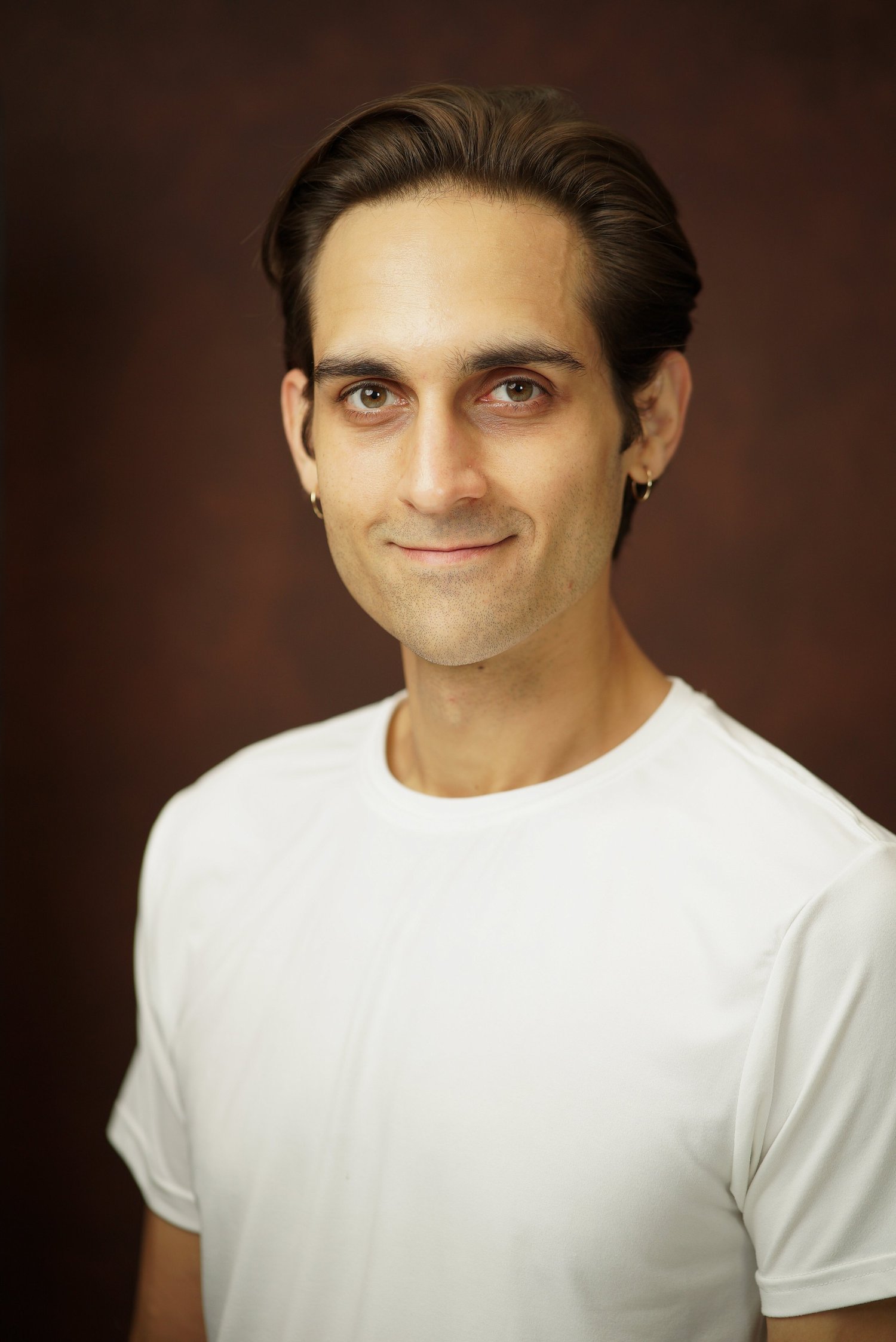 Milan Babi smiling commercial headshot in white shirt
