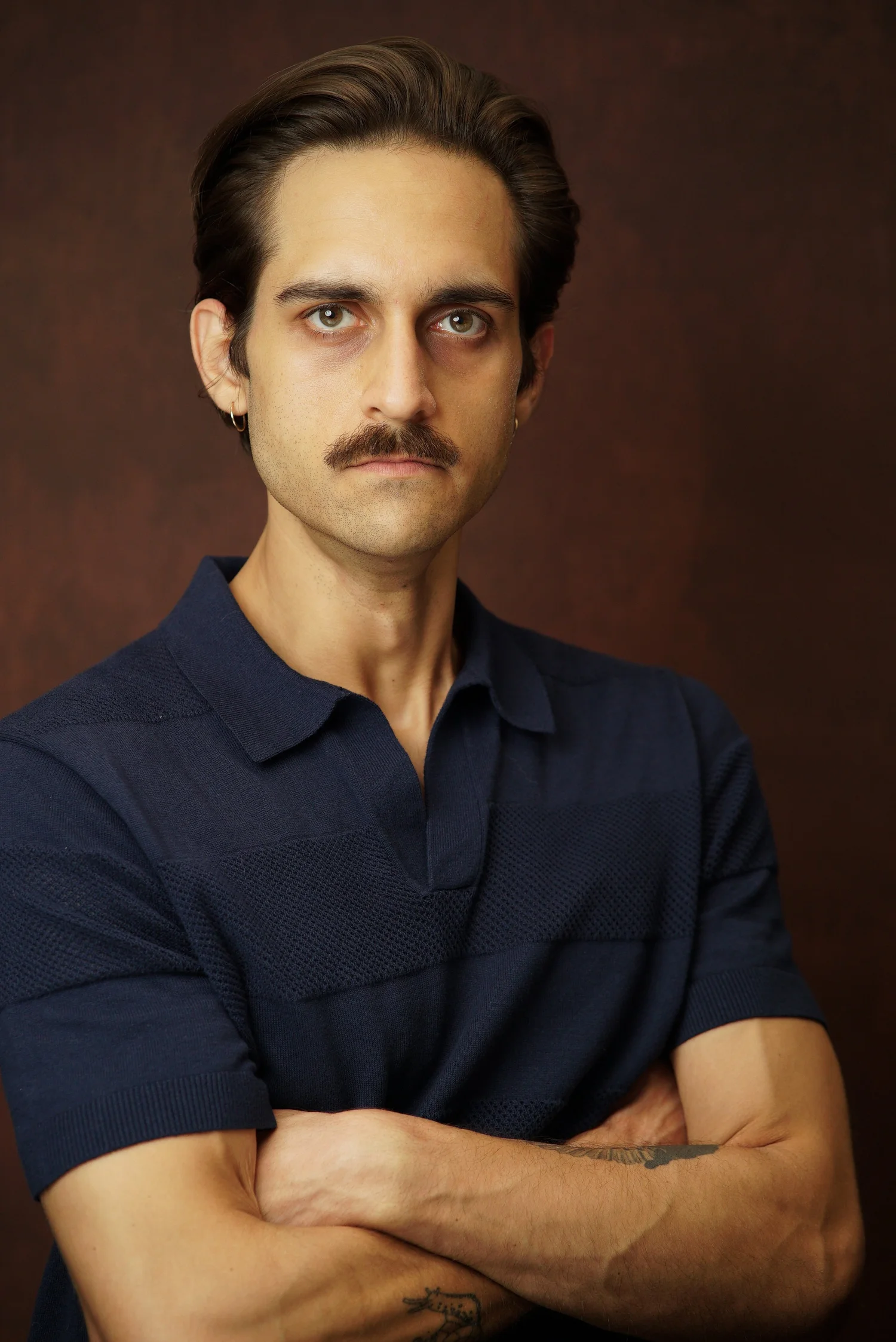Milan Babi serious arms crossed theatrical headshot