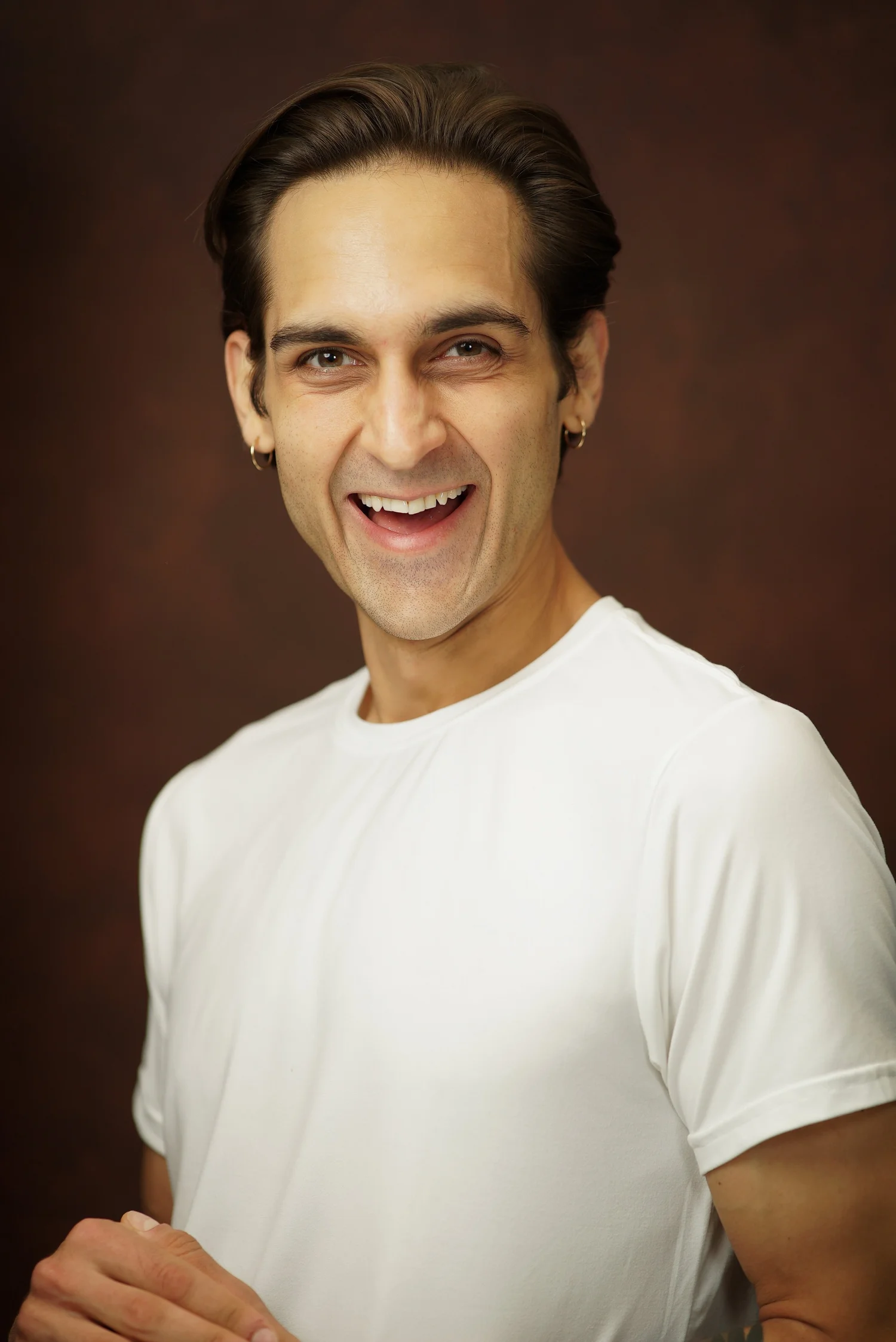 Milan Babi laughing commercial headshot in white shirt