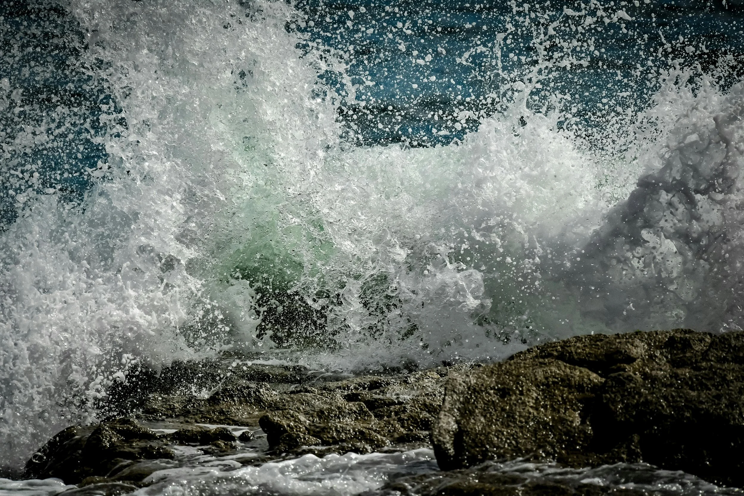 Vague de mer éclaboussant des rochers au bord de l'océan
