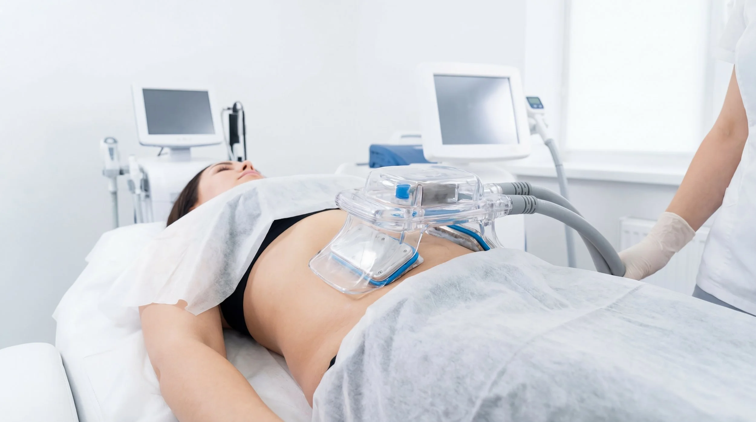 Patient allongée sur un lit d'hôpital sujet à une procédure médicale avec un appareil médical connecté à son abdomen.