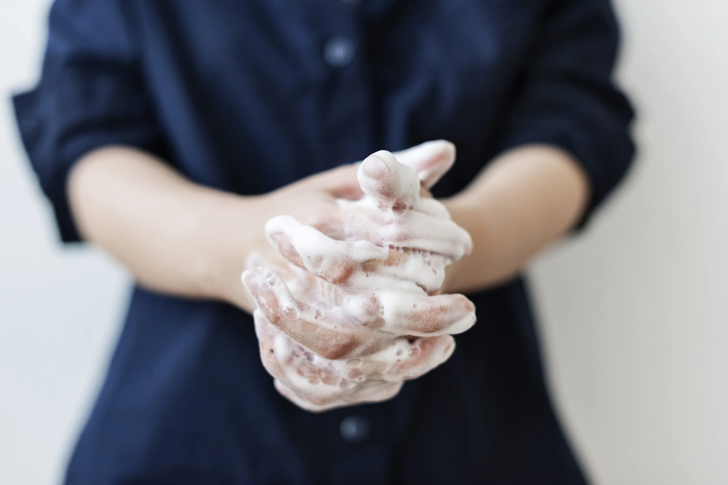 Person washing hands with soap lather.