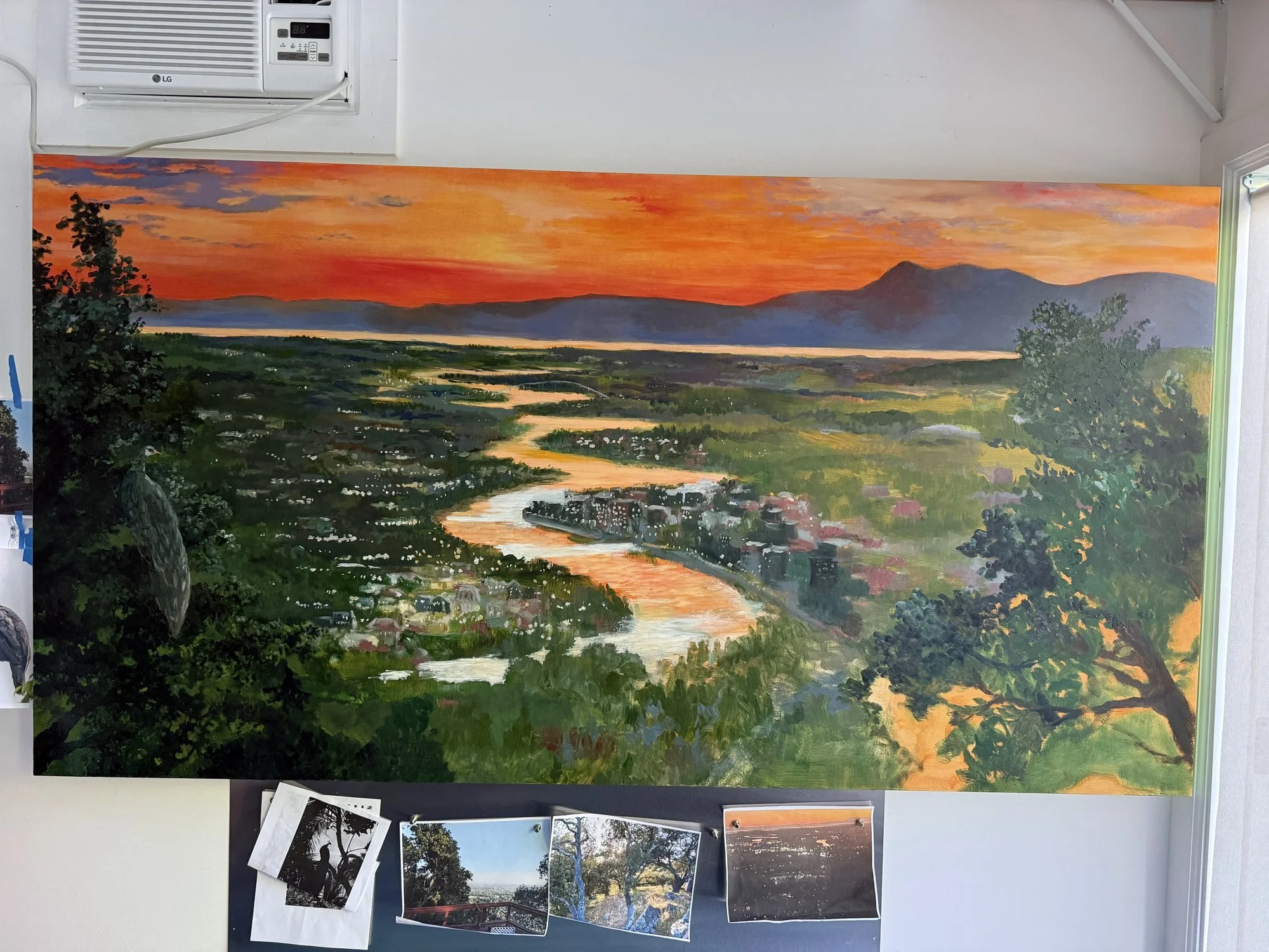 River of Light painting in progress on the studio wall, with reference photos pinned below