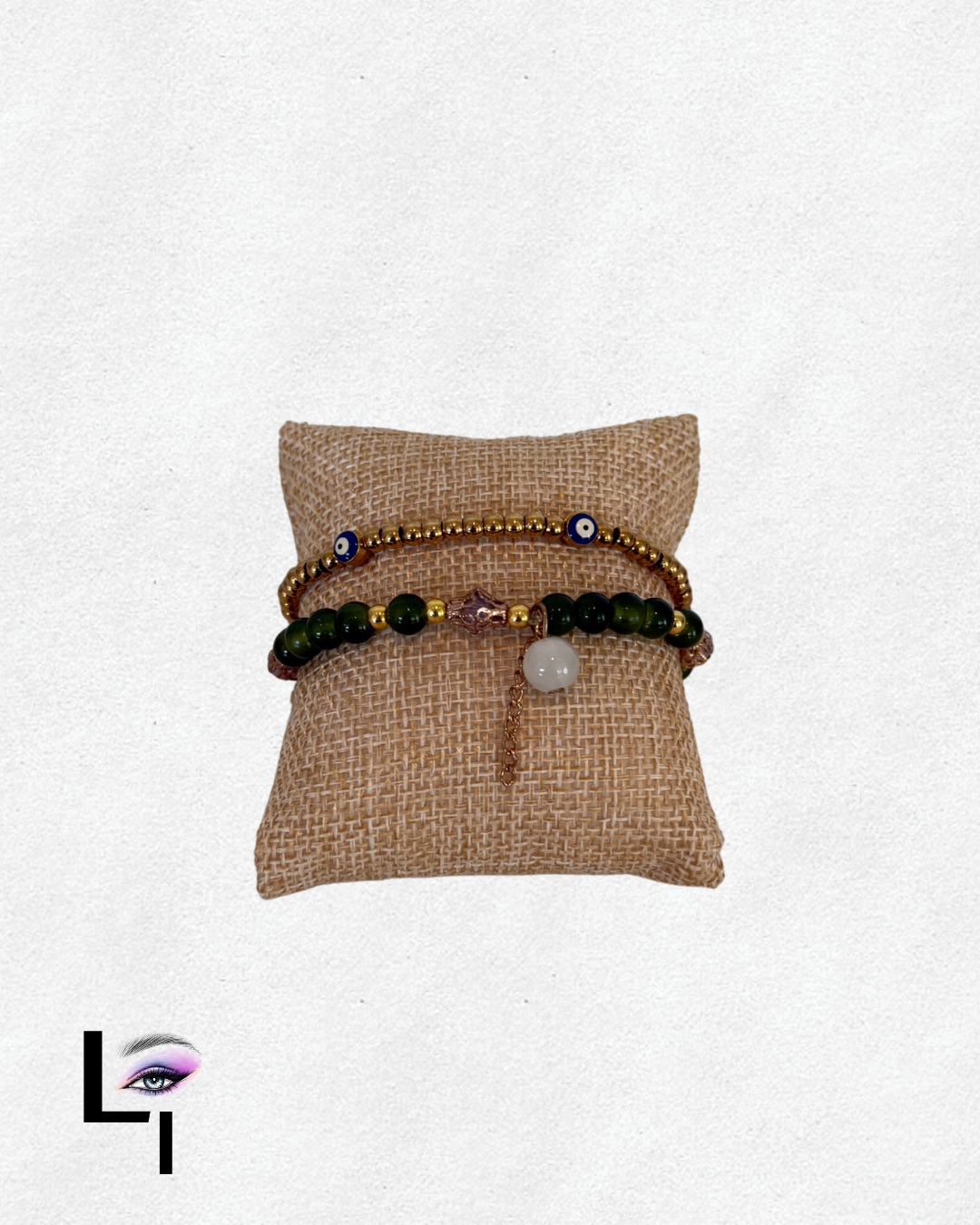 Beaded jewelry displayed on a small beige fabric cushion.