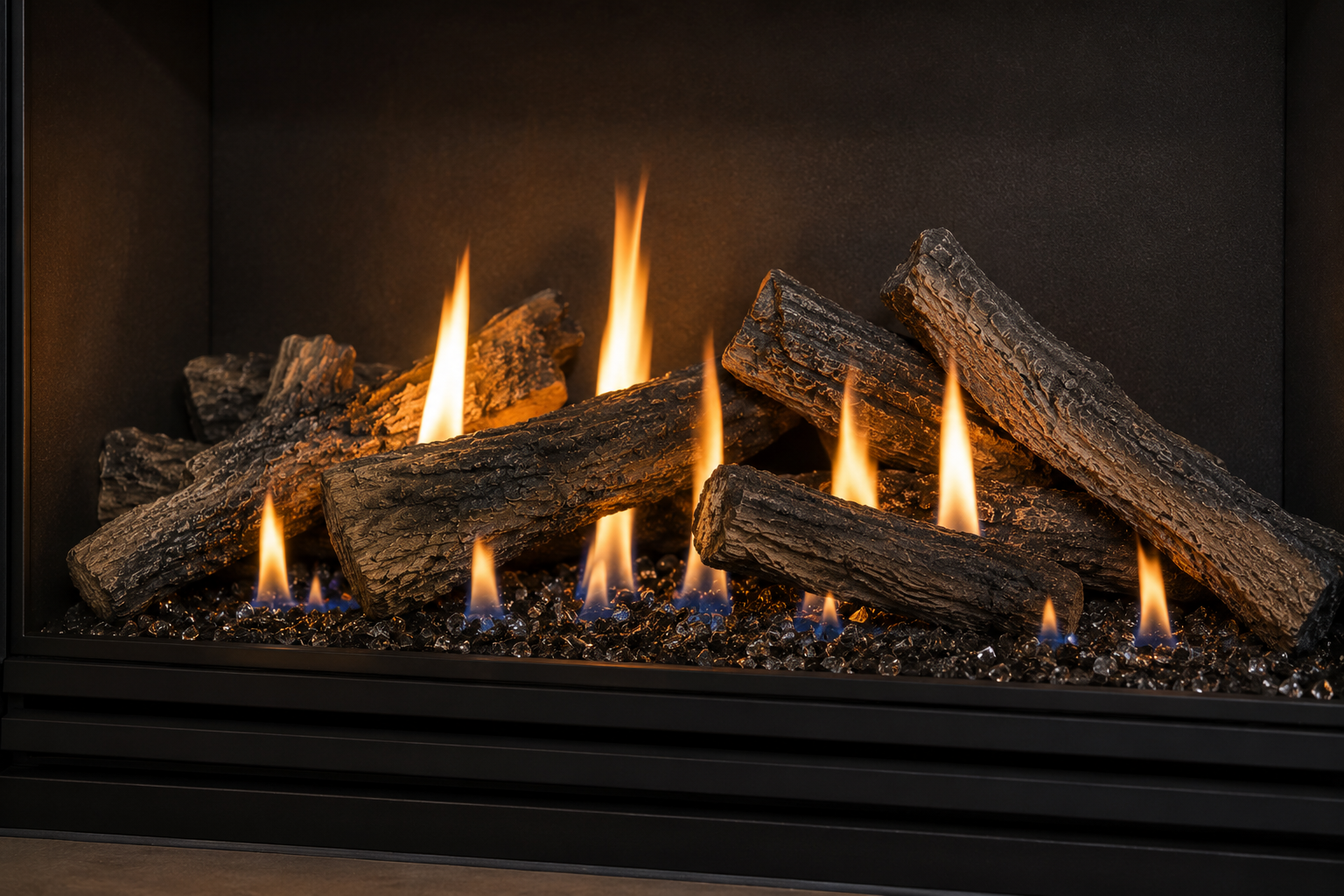 A close-up of a gas fireplace with glowing artificial logs and bright flames.