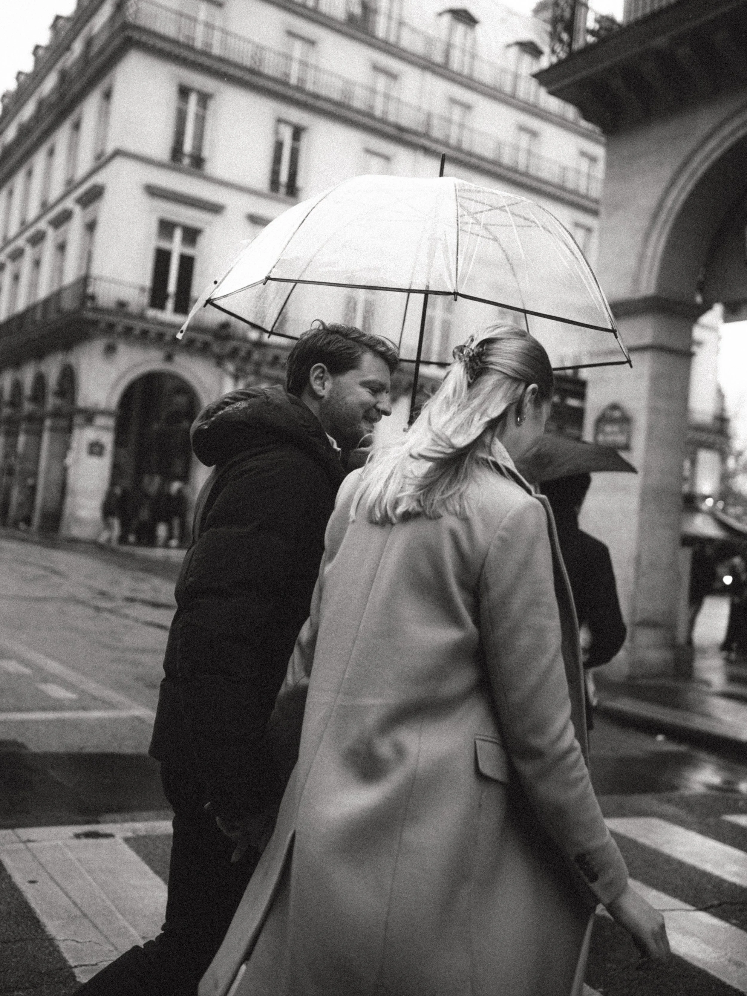 couple crossing a street in Paris under the rain
