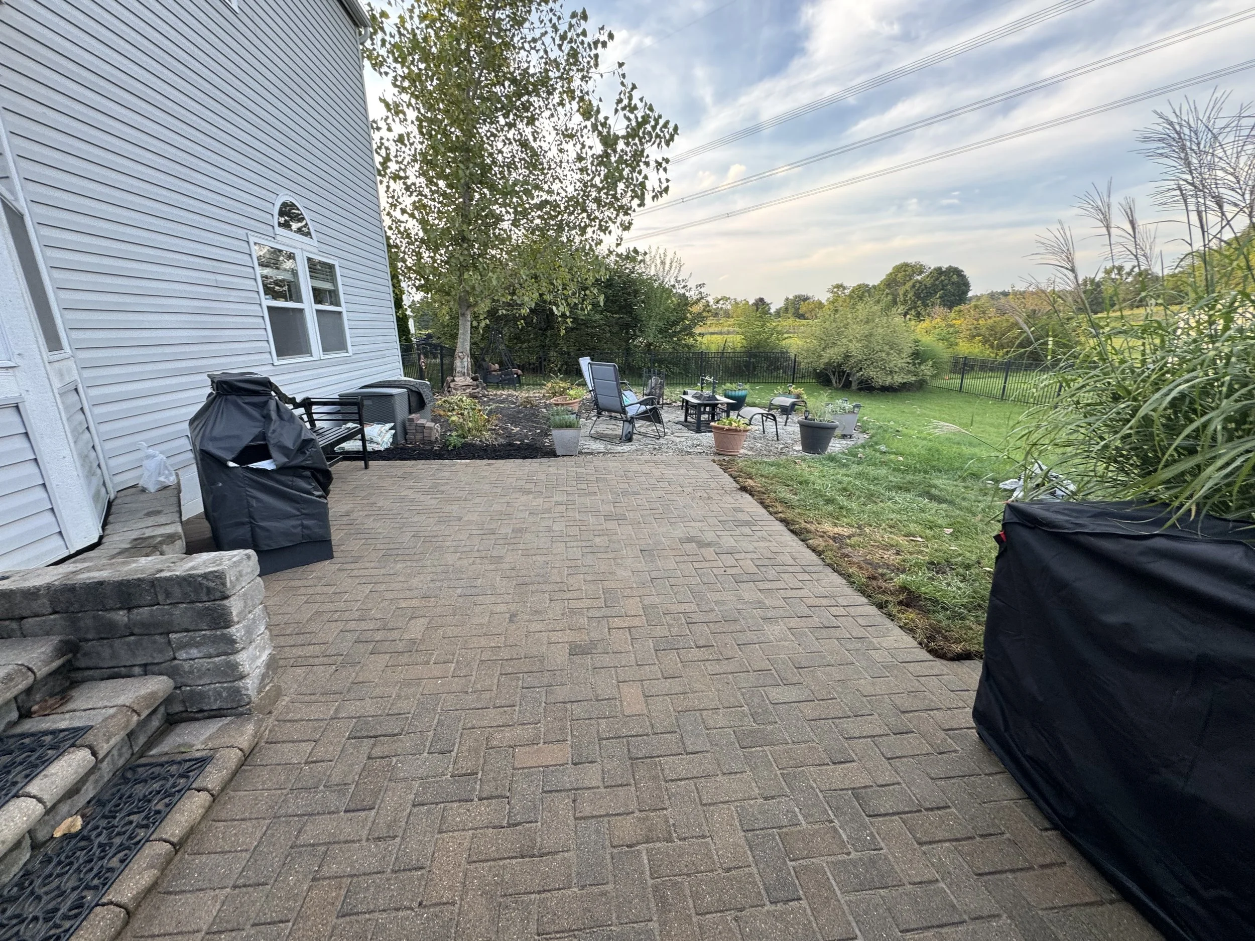 Herringbone paver patio tied into existing stacked stone steps in Galena Ohio