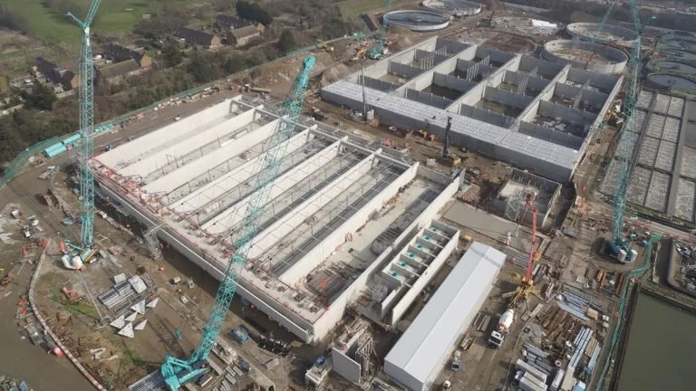 Aerial view of a large construction site with multiple cranes and building structures in progress.