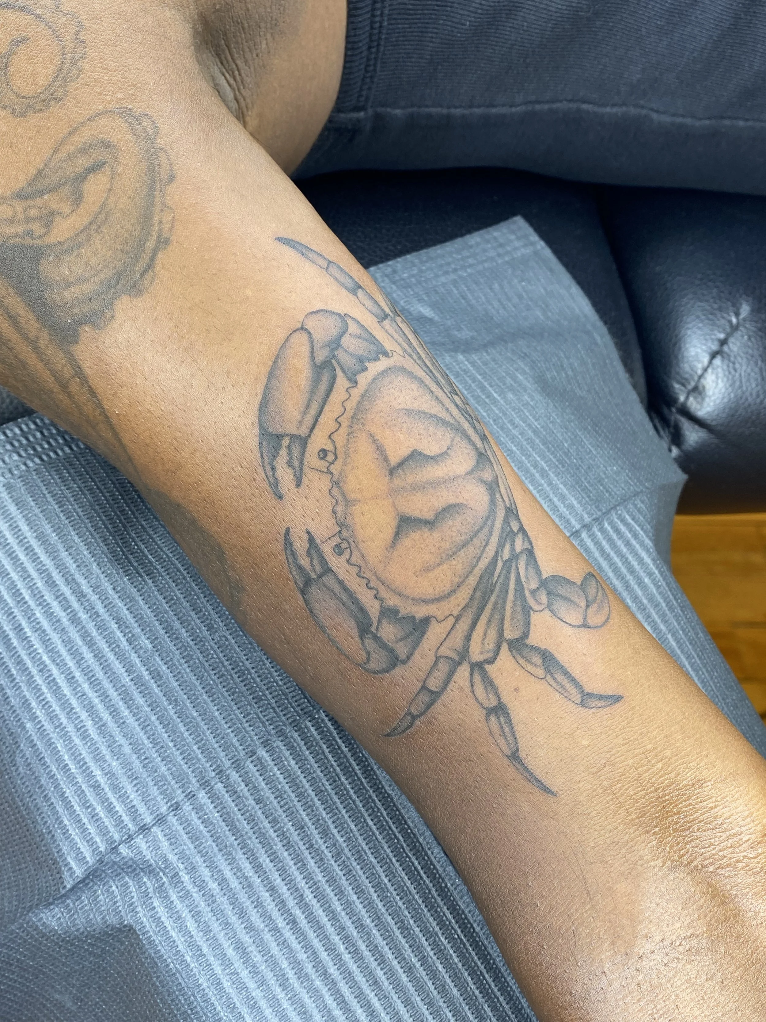 Tatouage d'une crevette sur le bras d'une personne.
