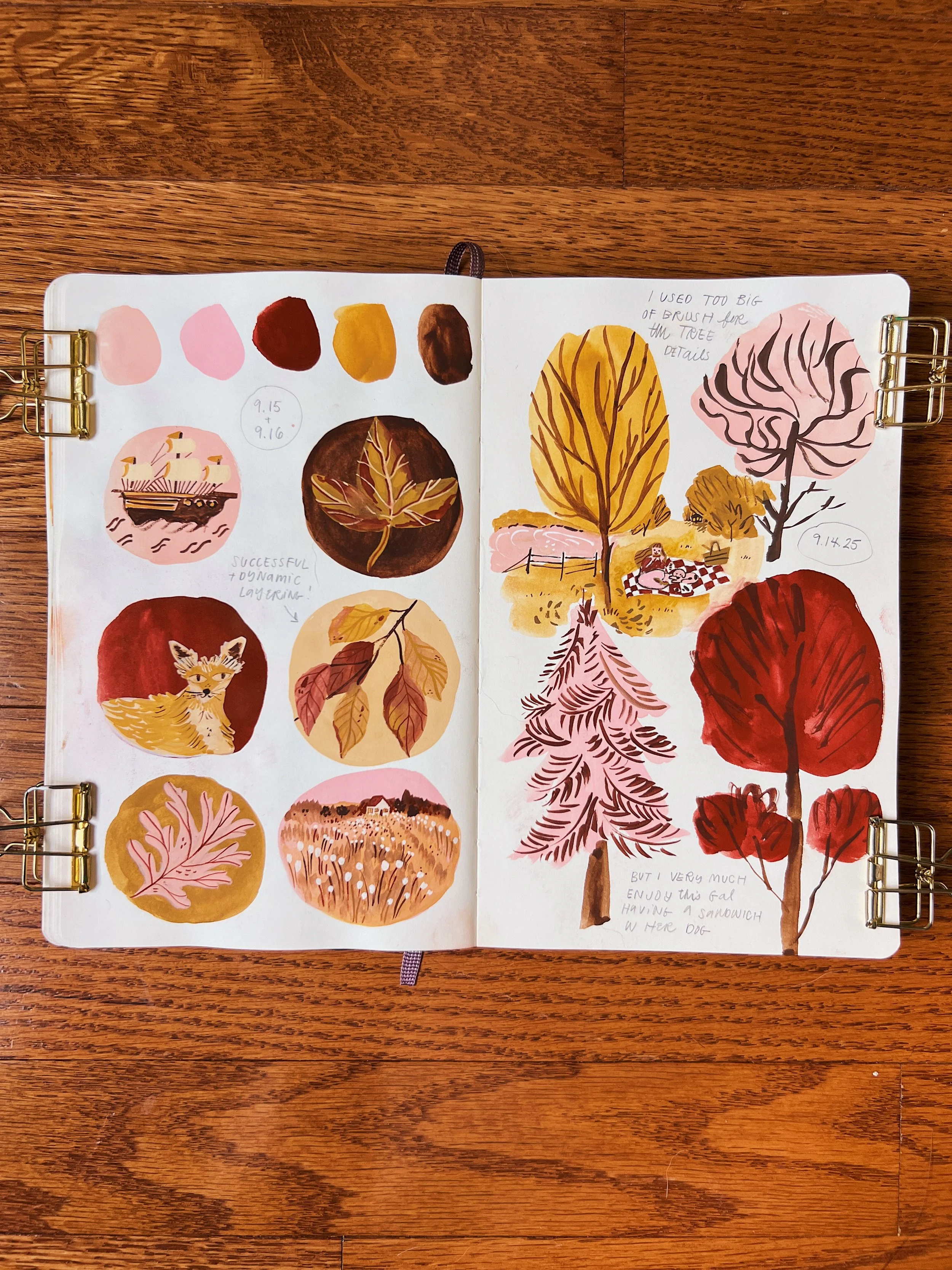 An open sketchbook shows autumnal vignettes painted in gouache featuring animals, landscapes, and florals