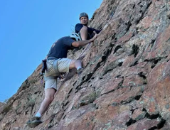Person rock climbing on a steep cliff face