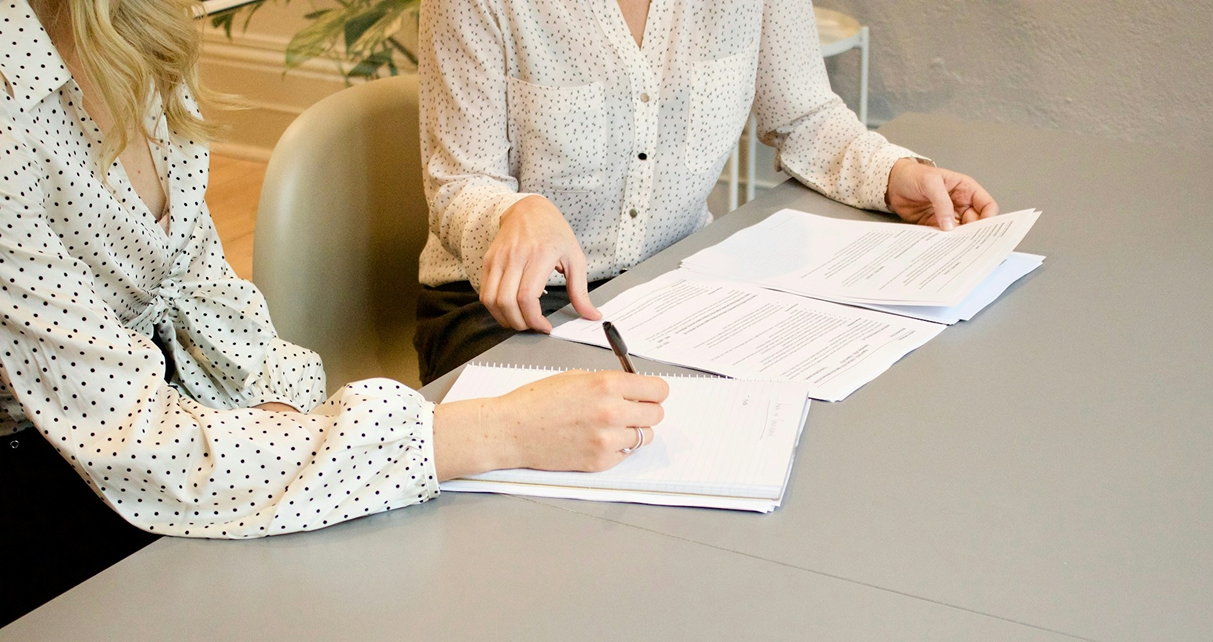 An early career physician and hospital hr person go over a new physician contract