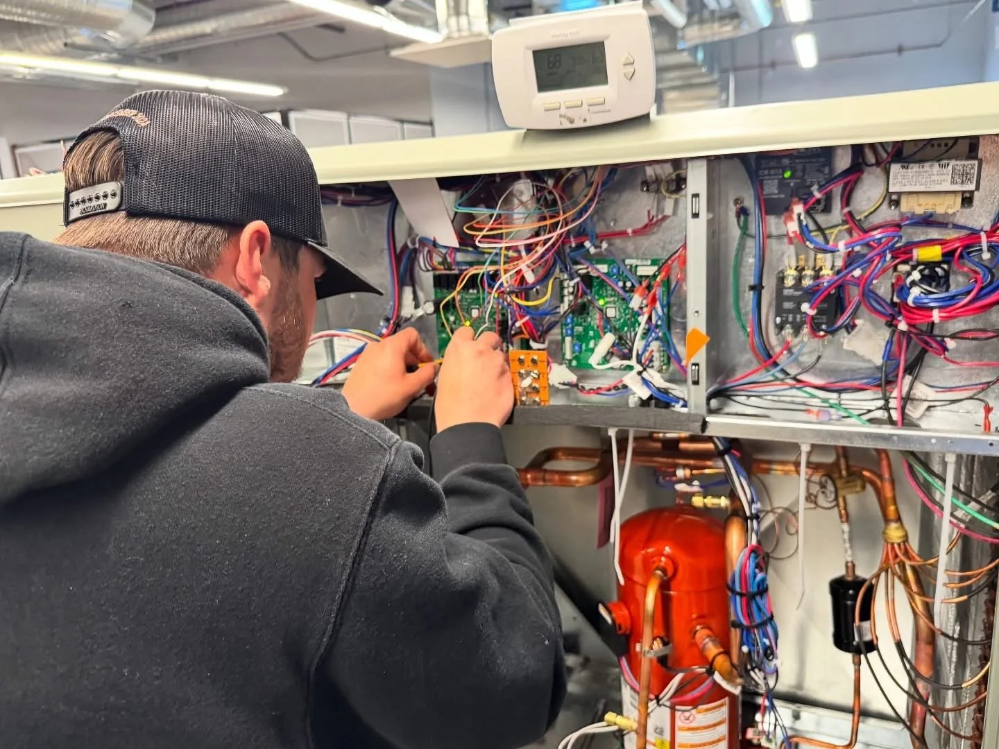 A person adjusting a 'FIRE DAMPER' on a metallic fire suppression system.