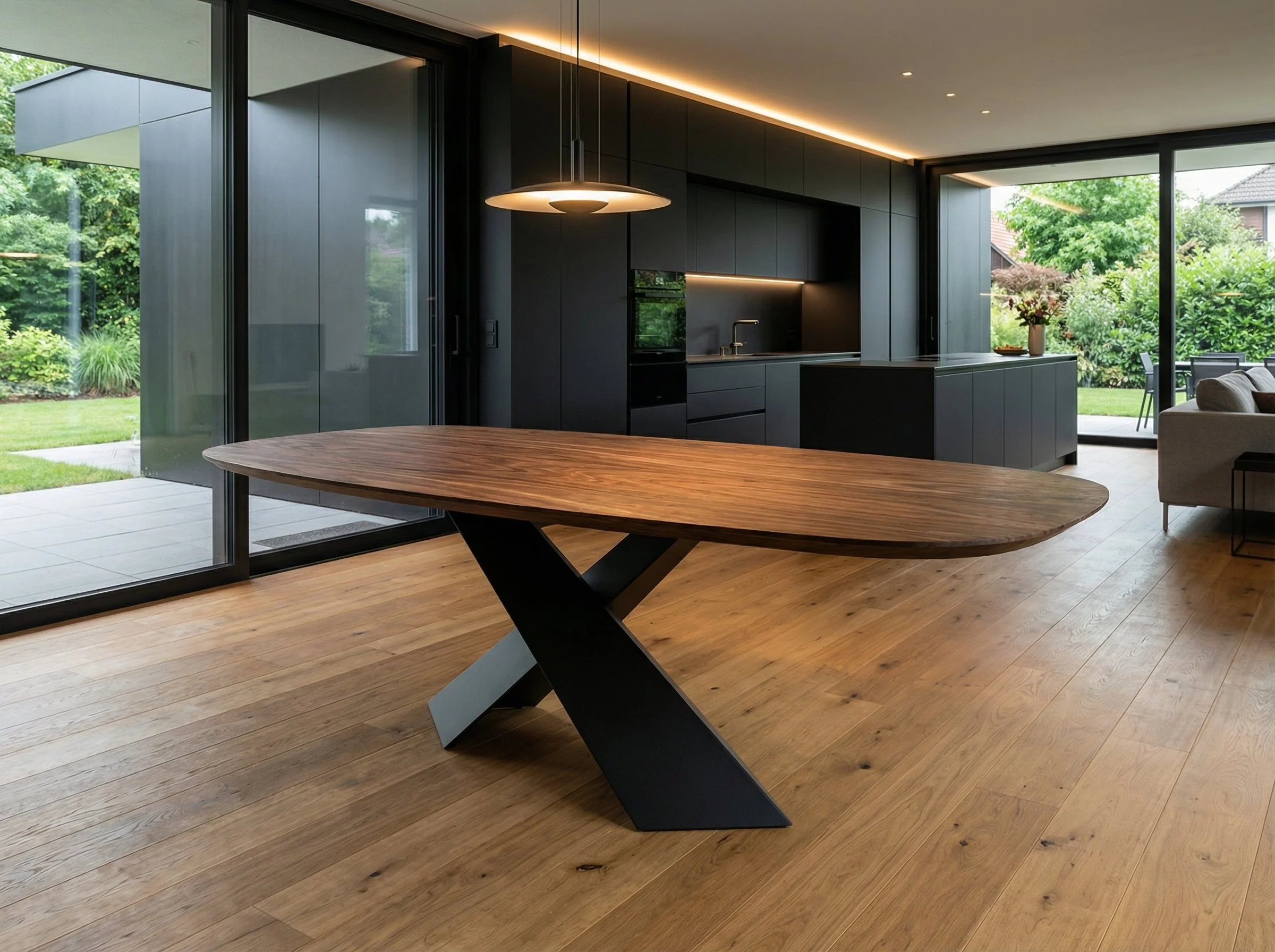 Interno di una casa moderna con cucina nera, tavolo di legno, parquet in legno e grandi finestre con vista sul giardino.