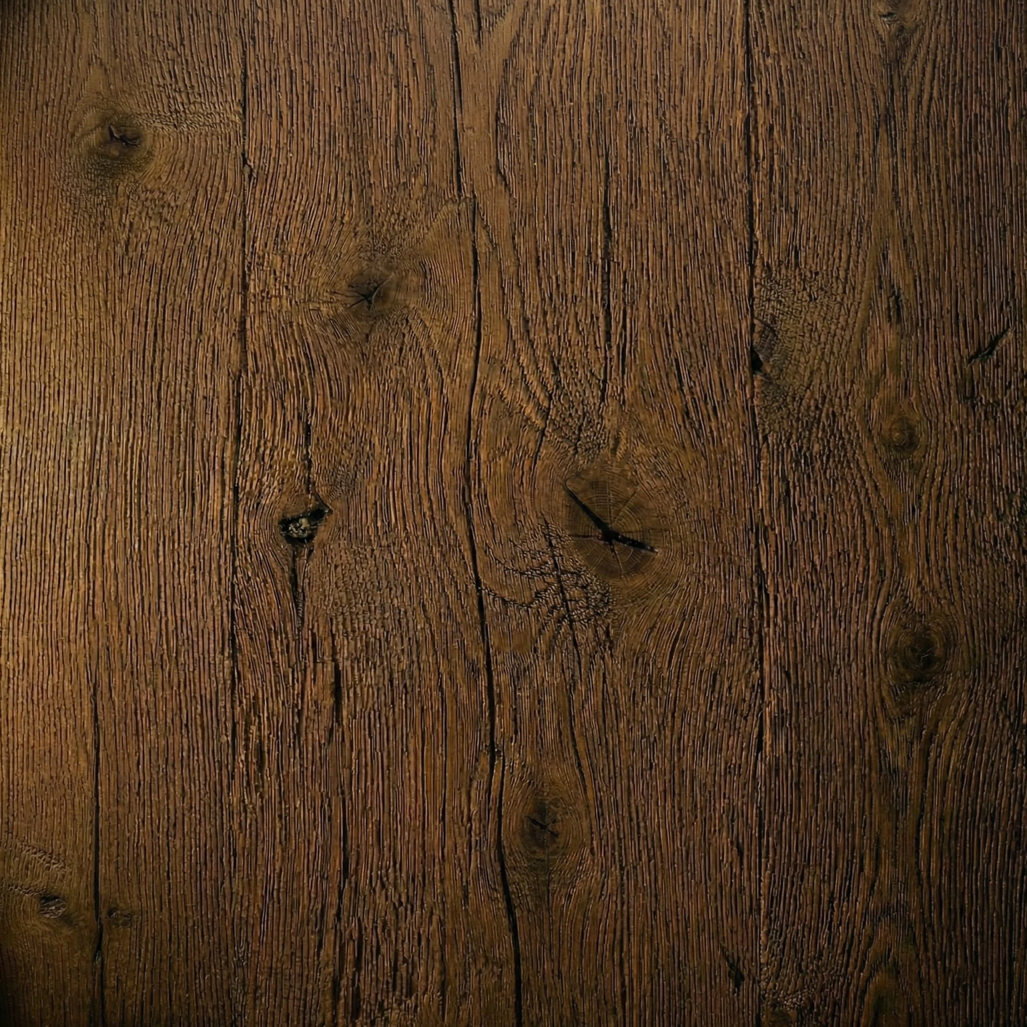 Superficie di legno con venature e nodi evidenti.