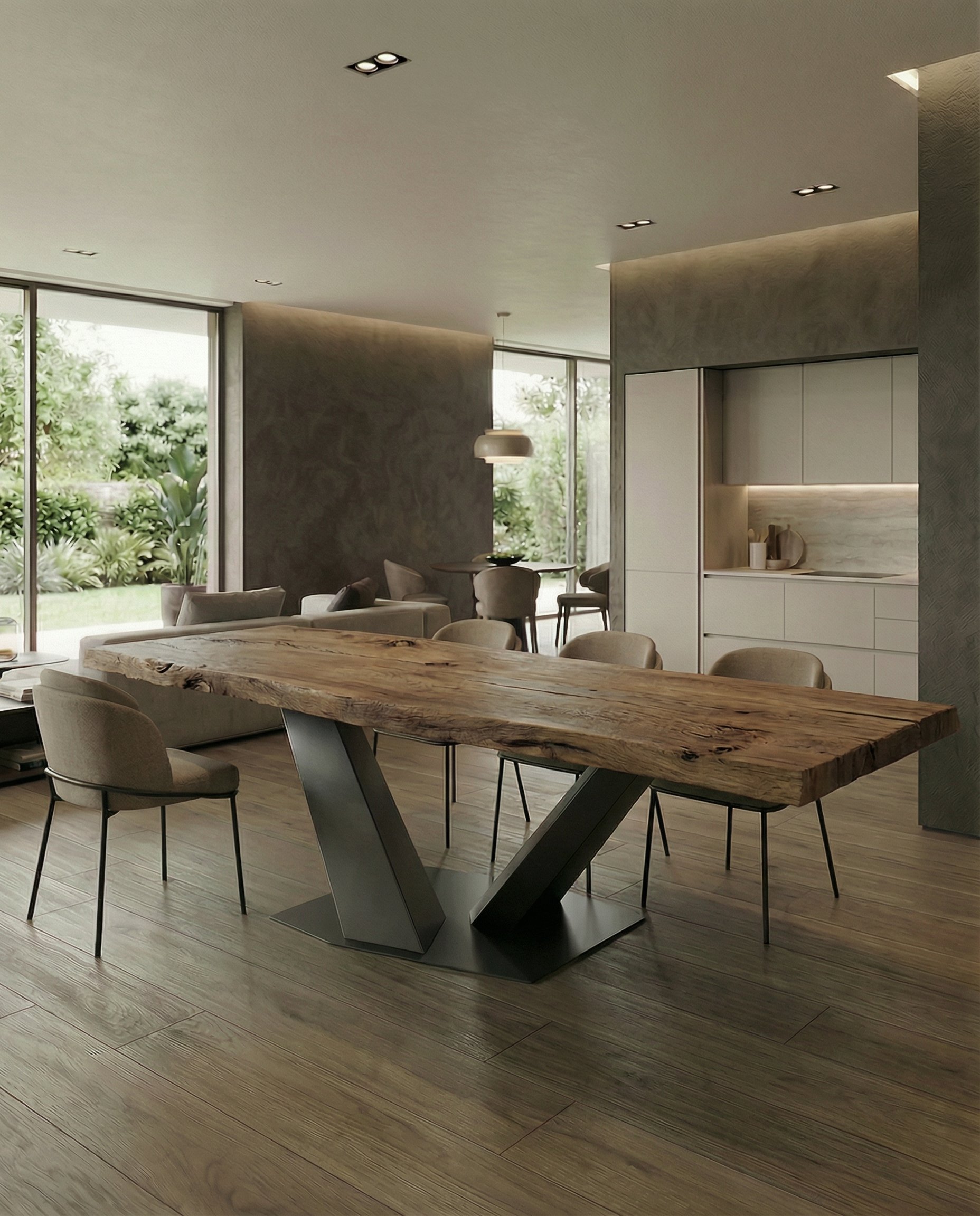 Interno di una casa moderna con tavolo in legno massello e sedie, zona soggiorno e cucina con grandi finestre che mostrano un giardino verde