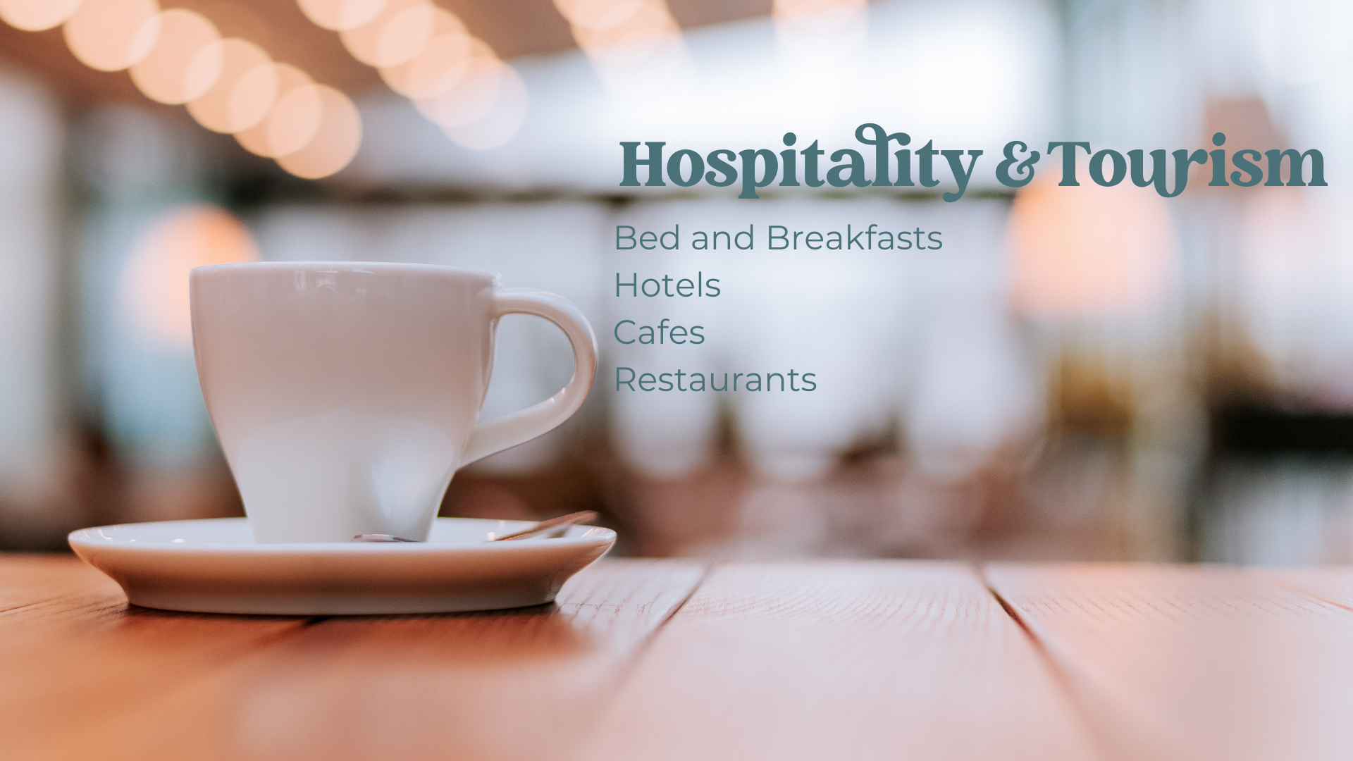 A white coffee cup on a saucer placed on a wooden table with blurred lights in the background. Overlaid text reads "Hospitality & Tourism" and lists "Bed and Breakfasts," "Hotels," "Cafes," and "Restaurants."