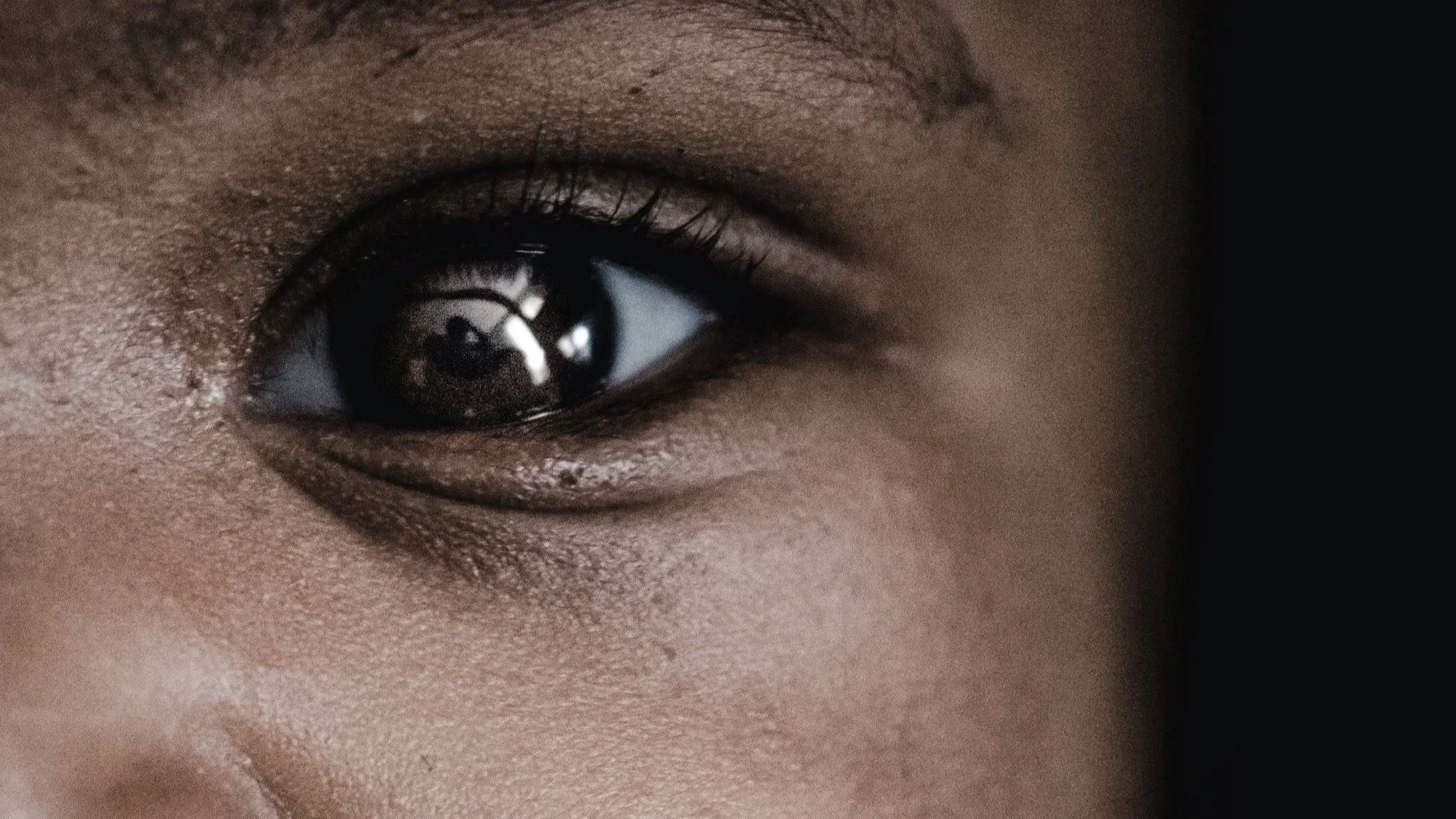 An image of a black child's eye, making us think about Femi's boy's innocence and anxiety at what he sees in 'Thirteen'.