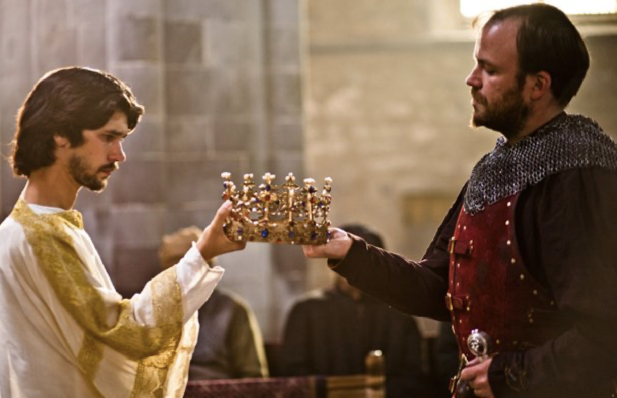 Richard on the left and Bolingbroke on the right hold a golden crown that's between them, studded with blue and red jewels.