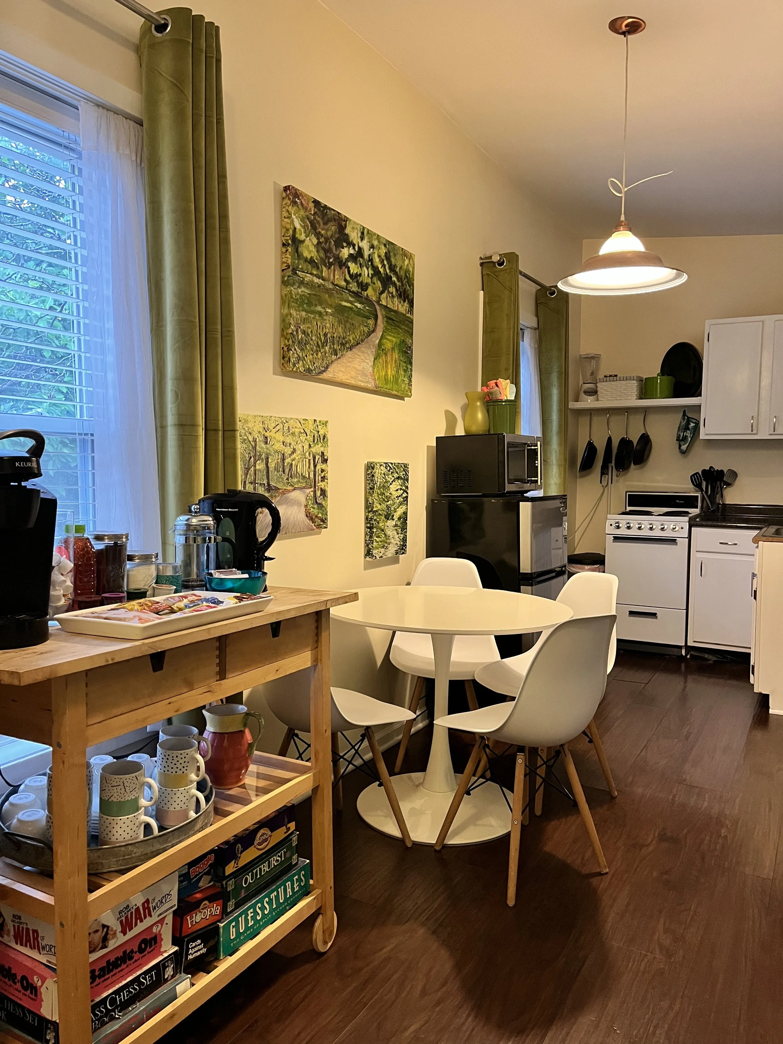 Cozy attic space with a colorful rug, red pillows, and various cushions, with a small window and ceiling light.