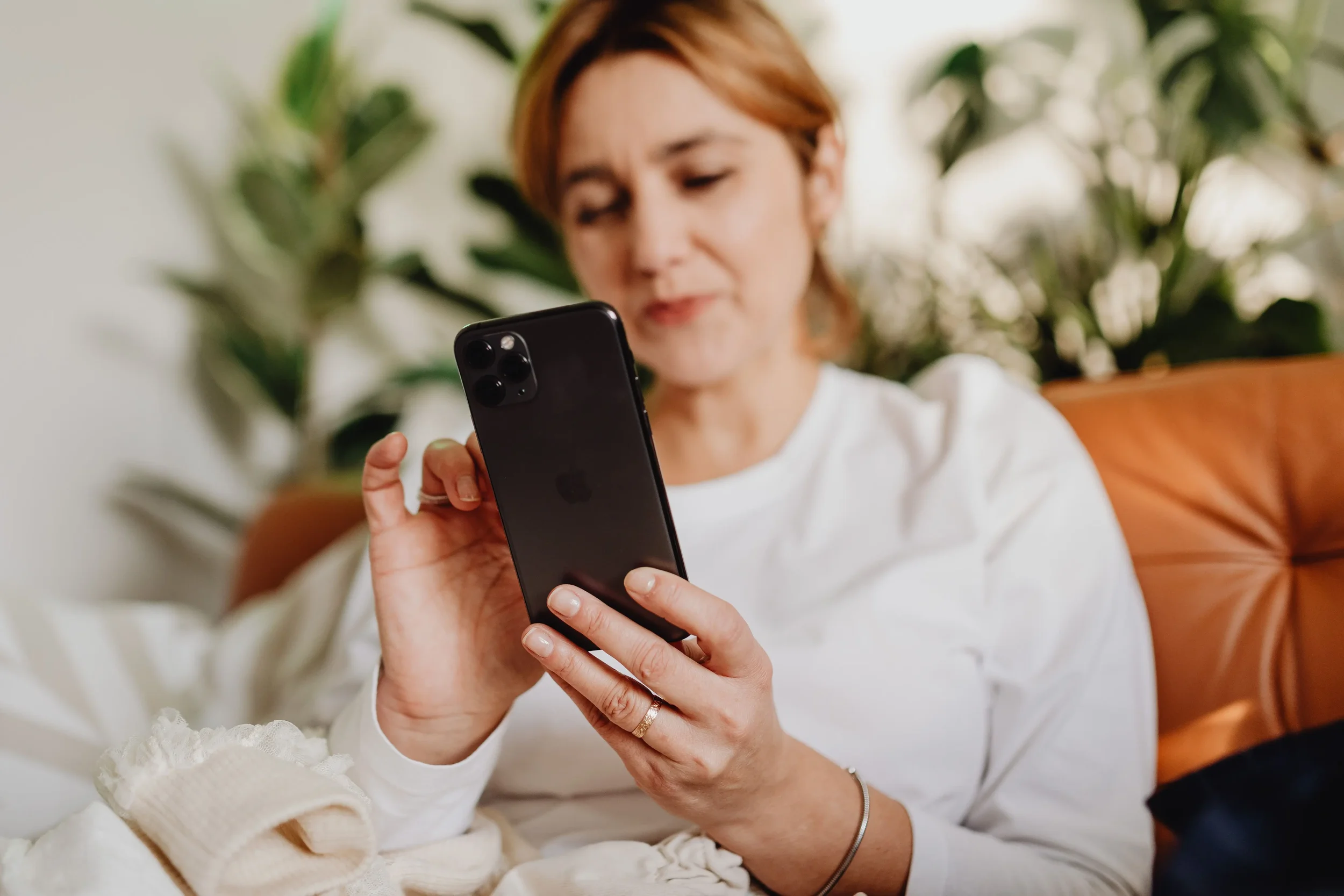 Therapist reviewing social media on a smartphone, representing audience engagement, content interaction, and relationship-focused growth for a private practice.