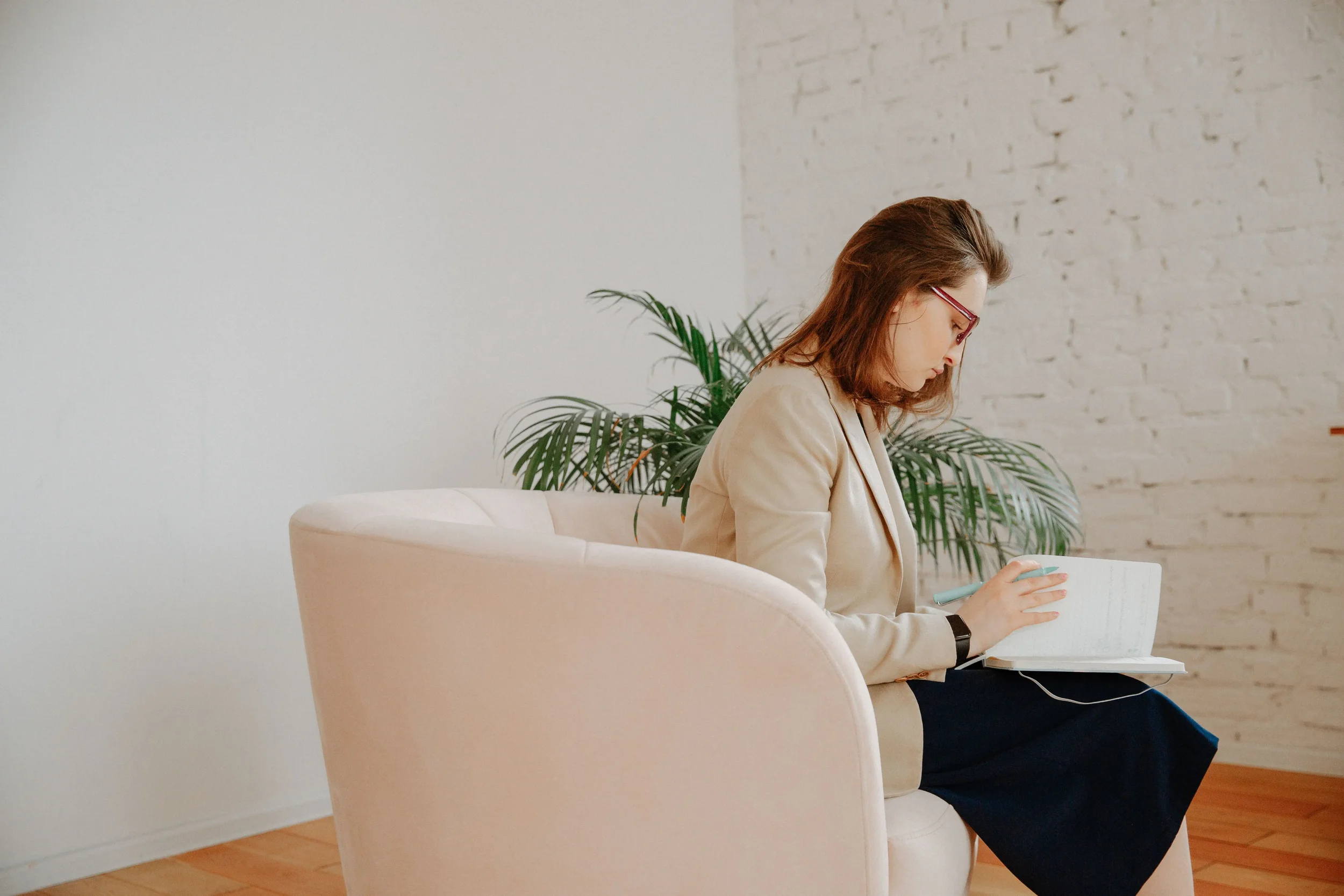 Private practice owner reviewing notes while planning ethical digital products and passive income options for a therapy business.
