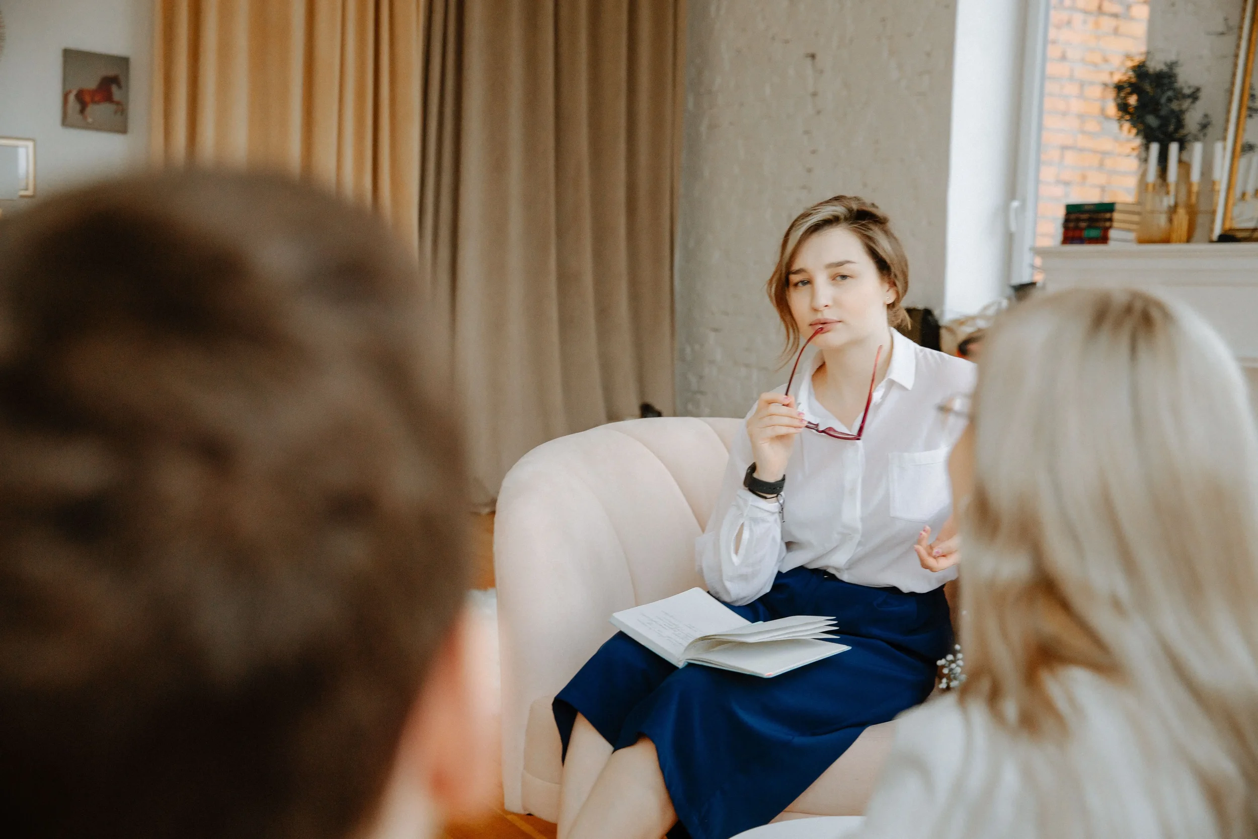 Private practice clinician discussing services with clients, representing how therapists can set sustainable session fees and plan practice income in 2026.