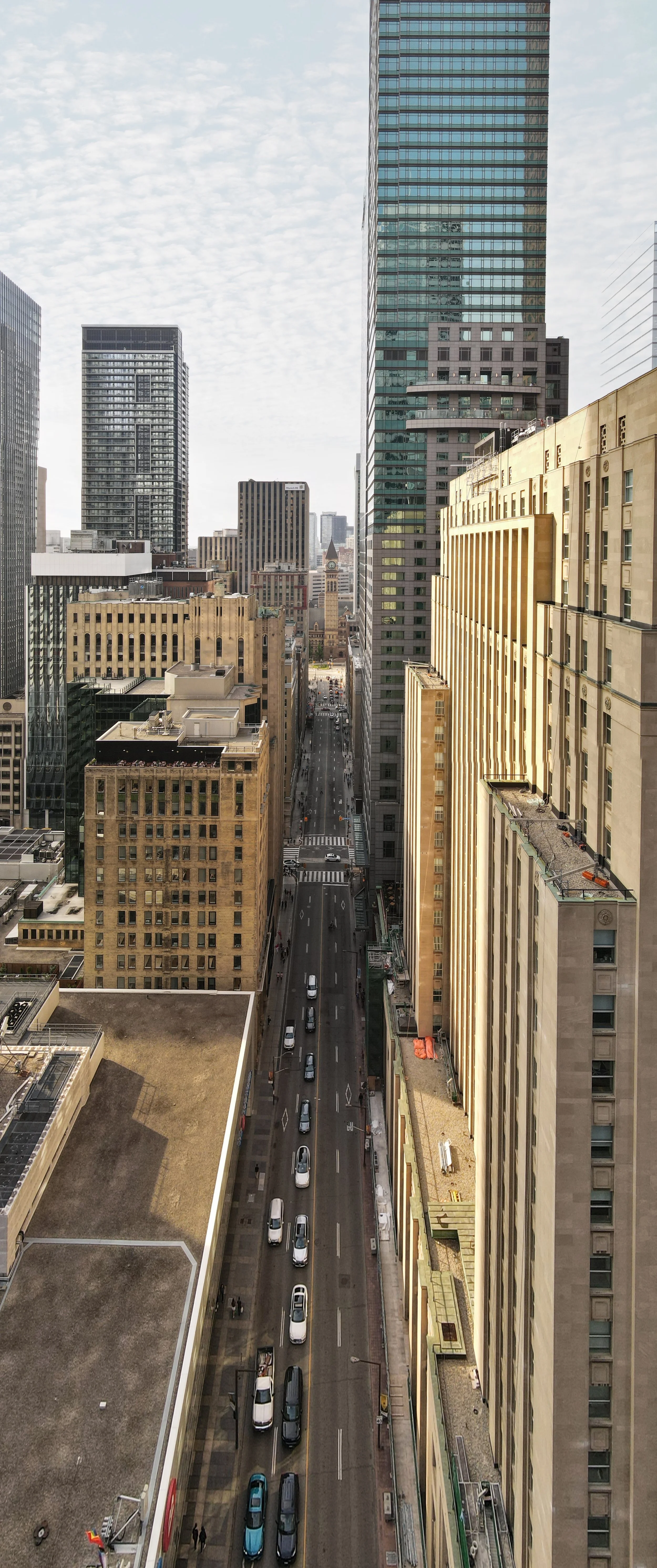 "Vertical panoramic view with Old City Hall visible in the distance, framed by the surrounding urban landscape and captured from above to highlight its historic presence amid modern Toronto."