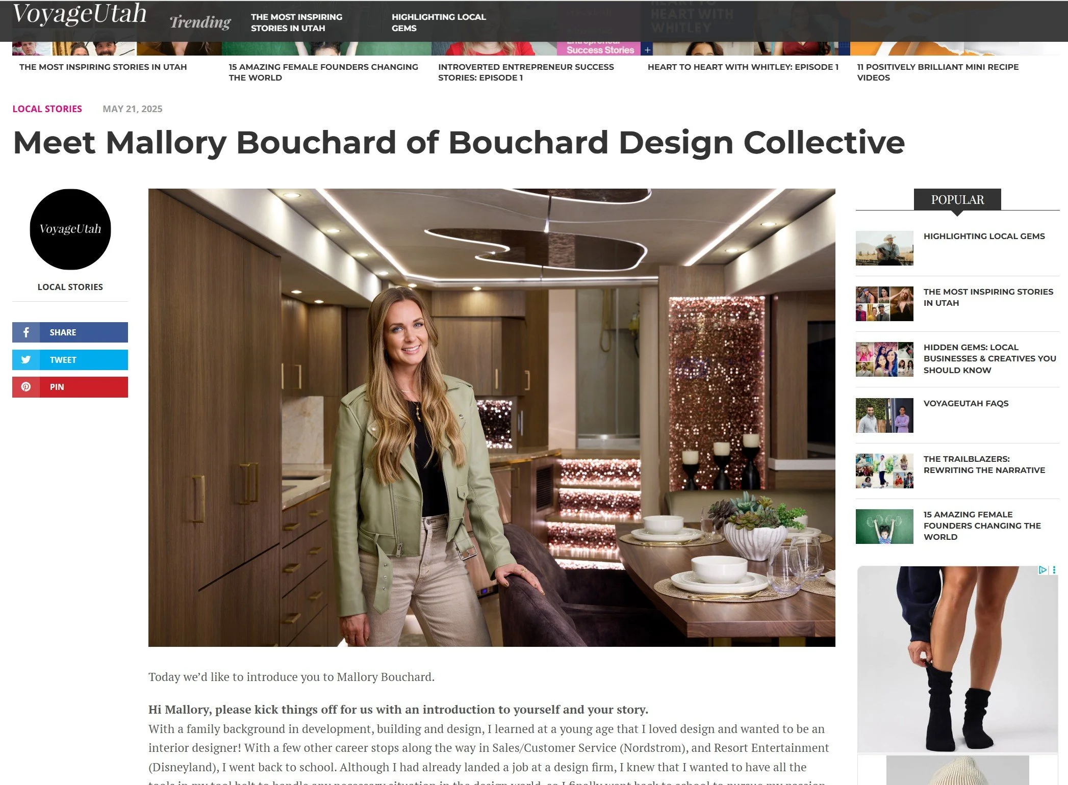 Mallory Bouchard standing in a modern kitchen with wooden cabinetry, decorative lighting, and a dining table set with white dishes and greenery.