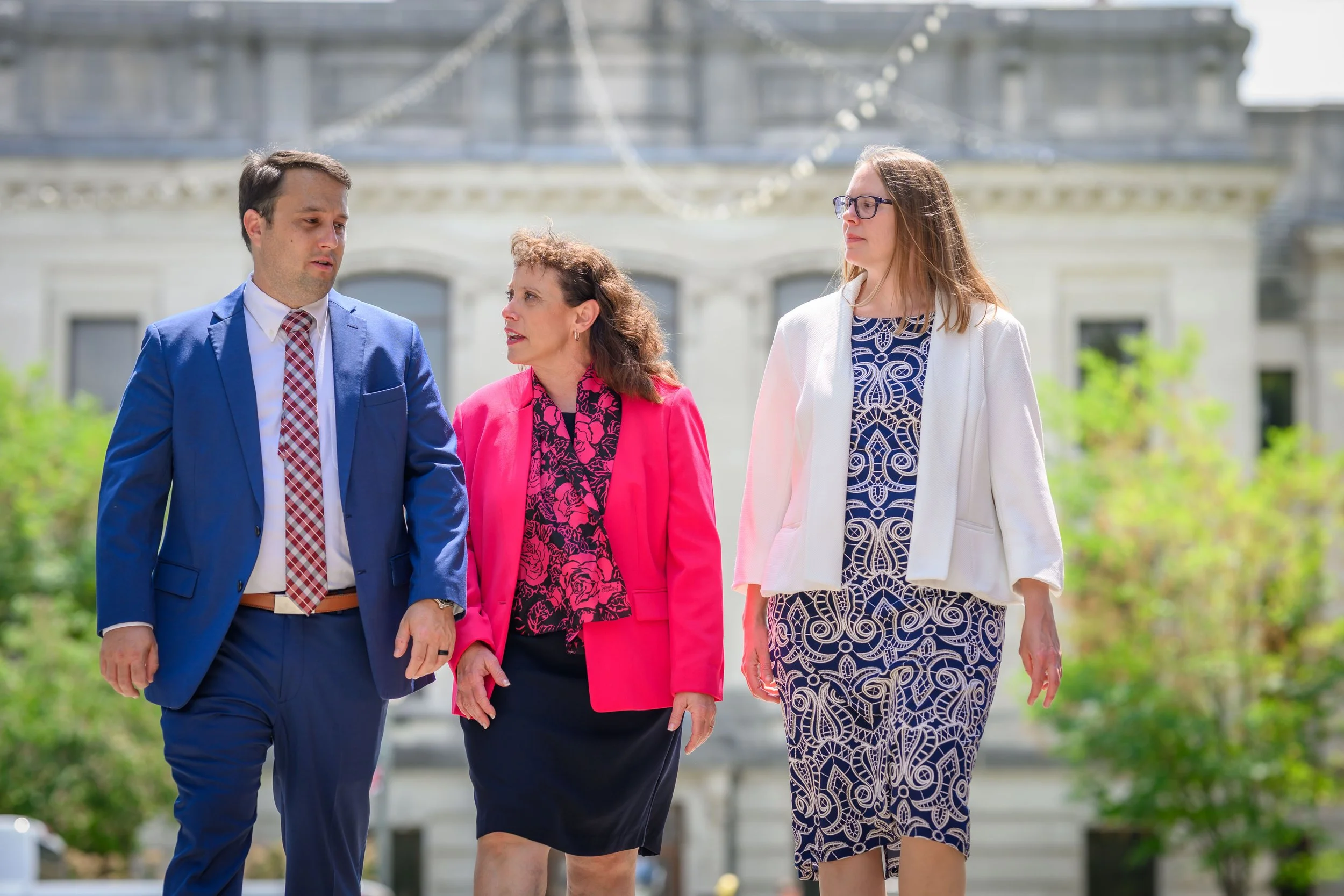 Amy Huffman Oliver consults with legal colleagues in front of a courthouse.