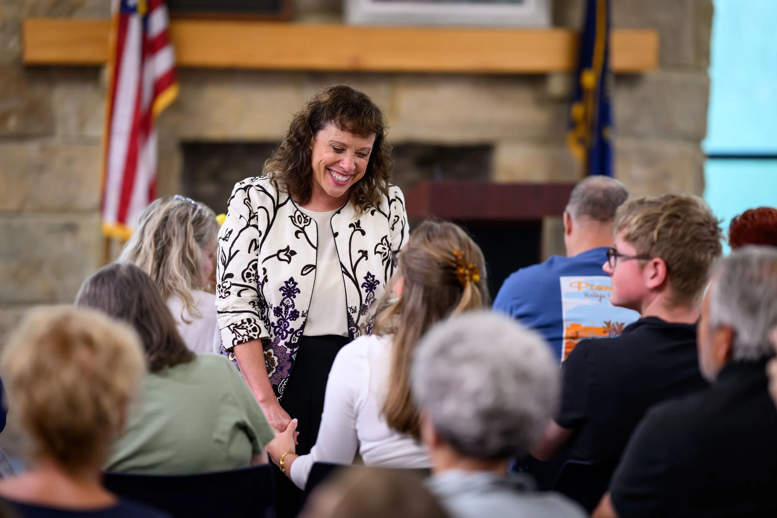 Amy Huffman Oliver speaks to a voter in a town hall setting.