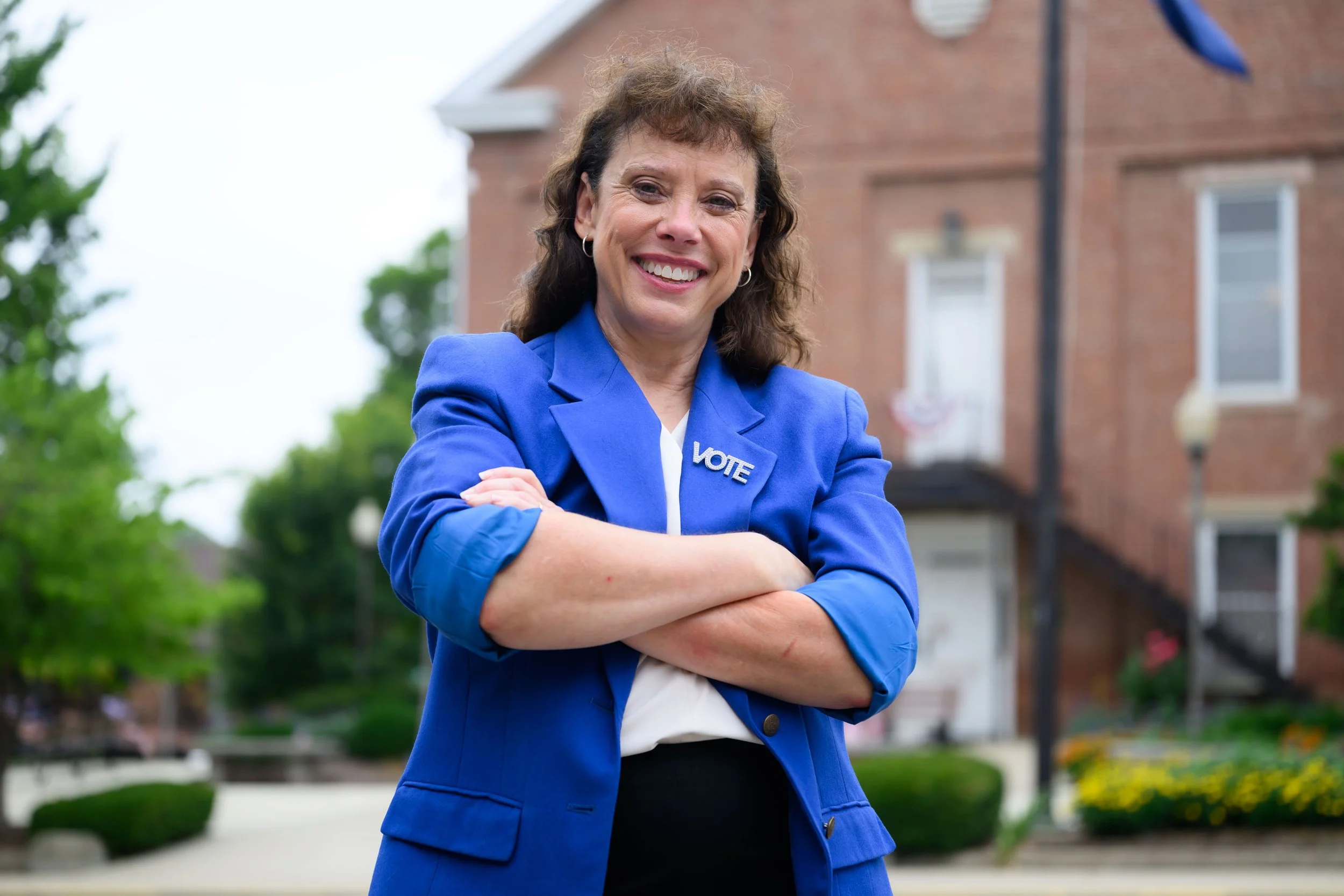 Amy Huffman Oliver smiles with her arms crossed in front of a courthouse.