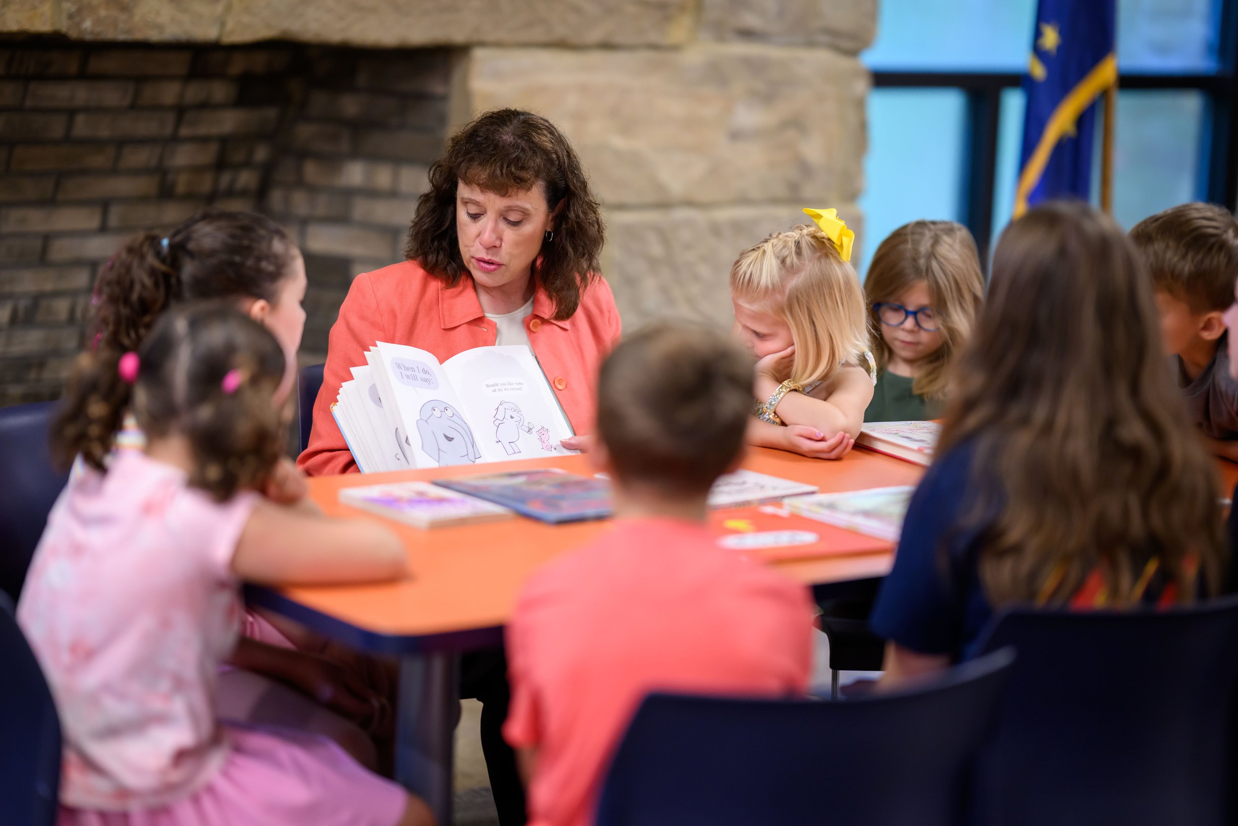 Amy Huffman Oliver reads a book to a group of young children.
