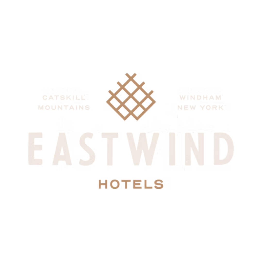 Logo for Eastwind Hotels with a geometric emblem and text indicating location in Catskill Mountains, Windham, New York.