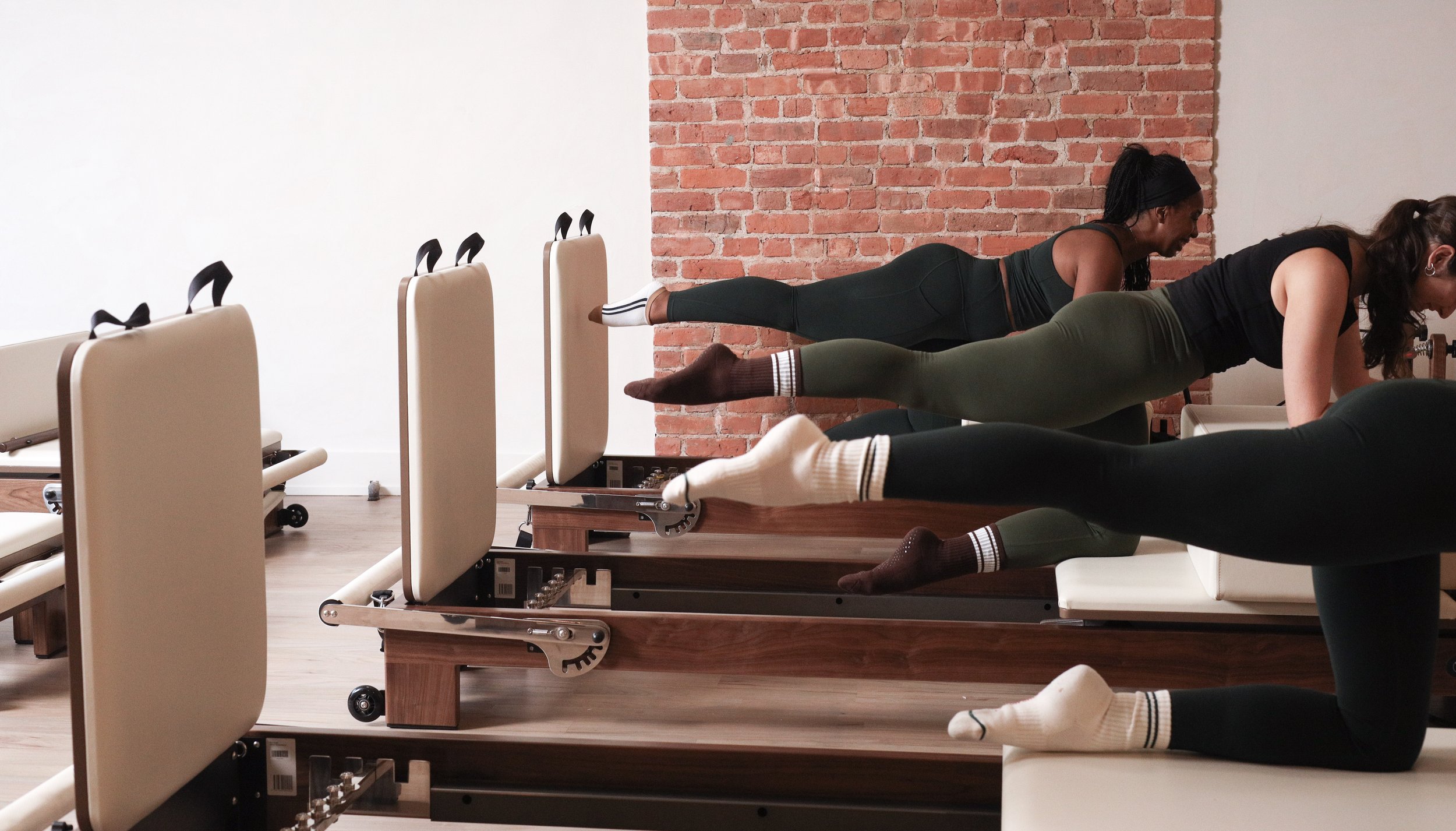 Professional Pilates trainers leading reformer and mat sessions at KIN Kollective