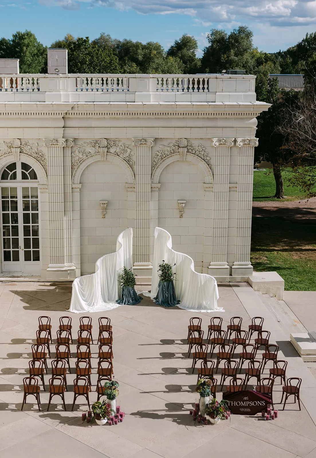 A wedding ceremony set up on the patio of an Italian style mansion