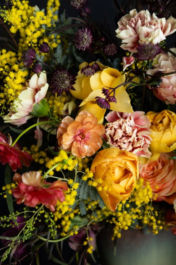 A close up of a yellow and pink bouquet of flowers