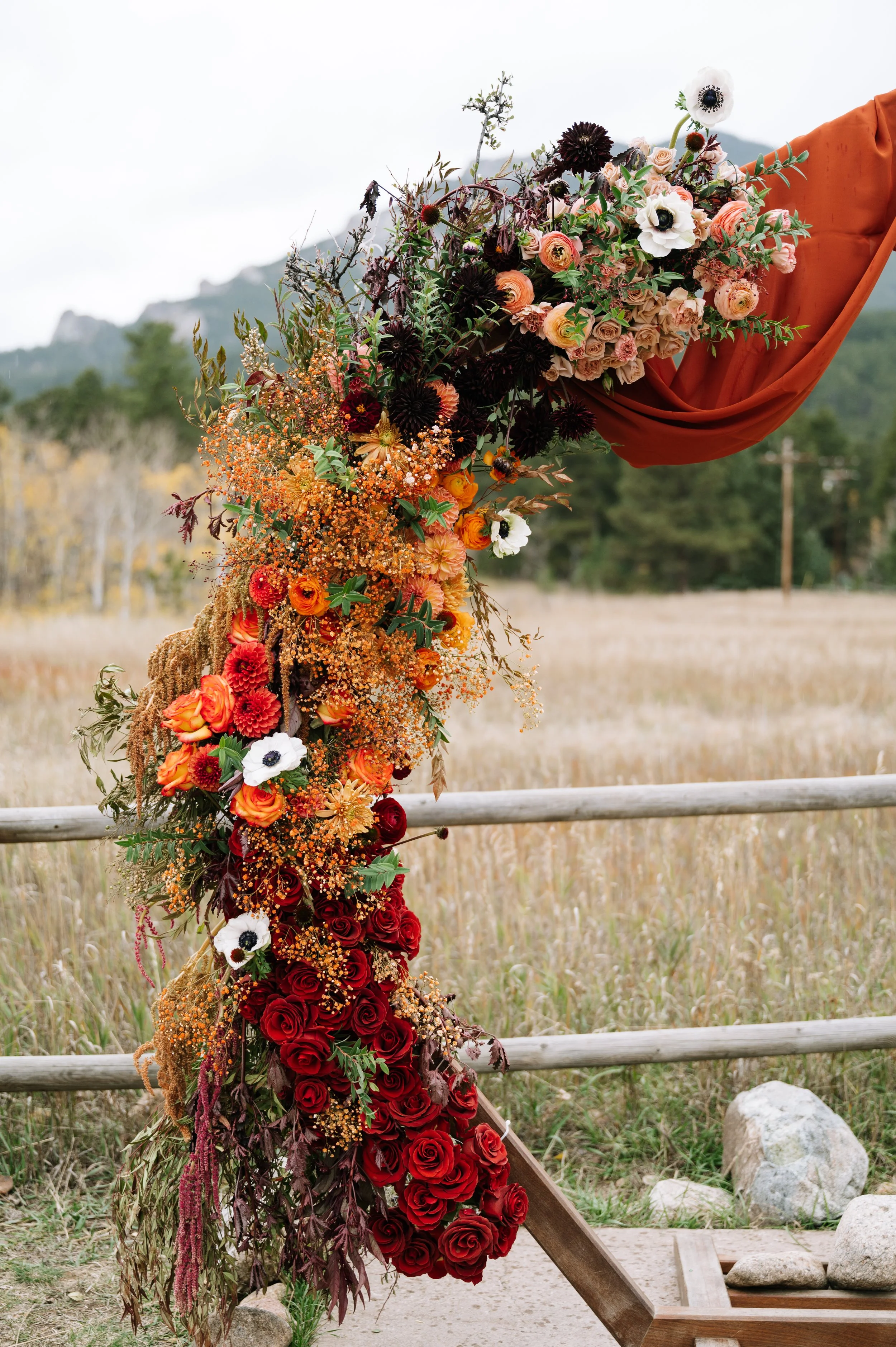 Colorado mountain wedding floral arch with autumn-toned flowers designed by Ash + Ether.
