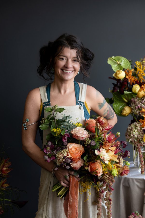 As smiling as she holds a bouquet of flowers