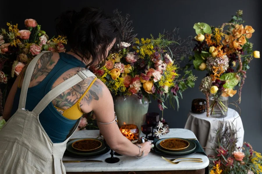 Ash adjusting a tablescape with flowers and flatware