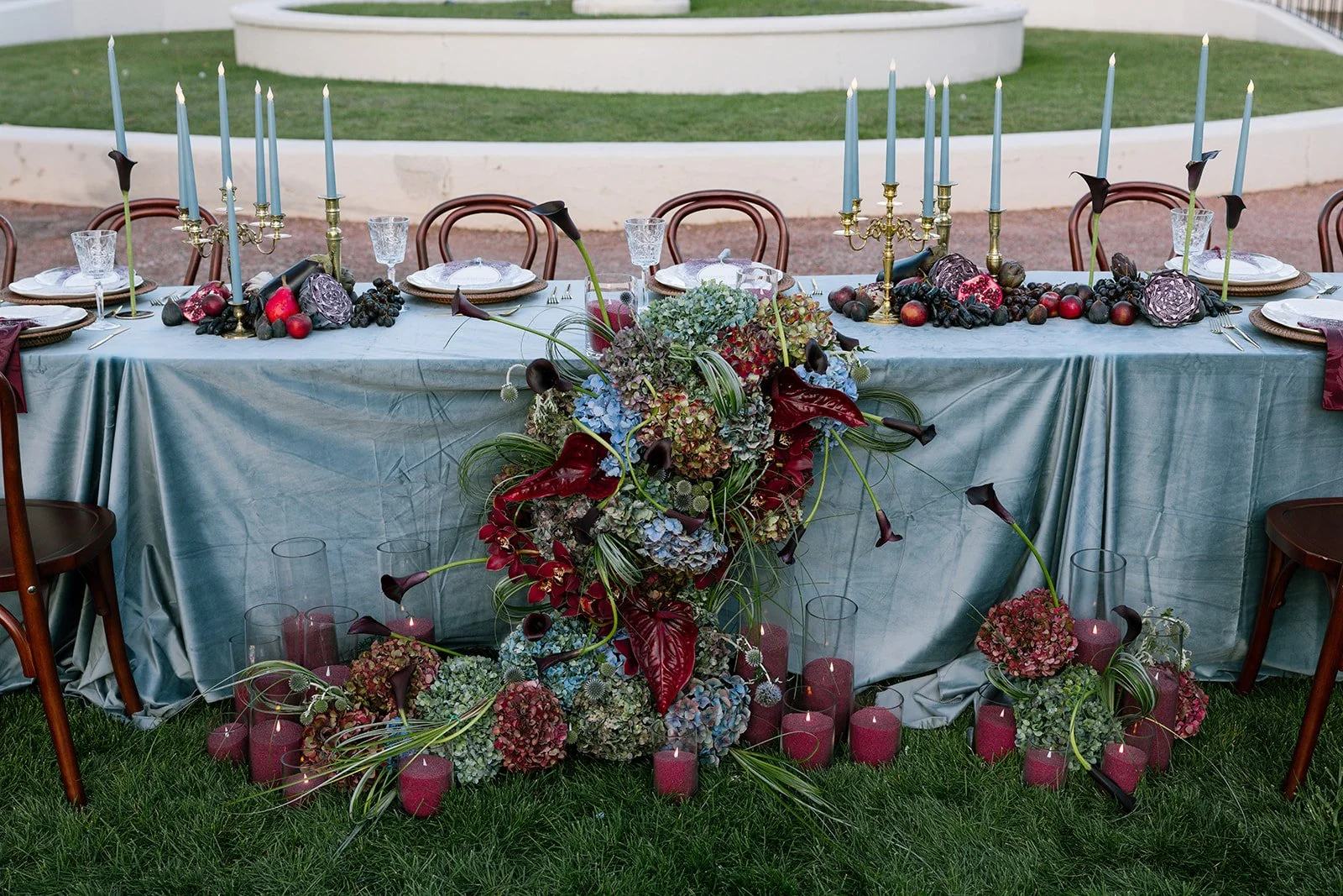 A wedding reception table with a large floral arrangement up the front of it