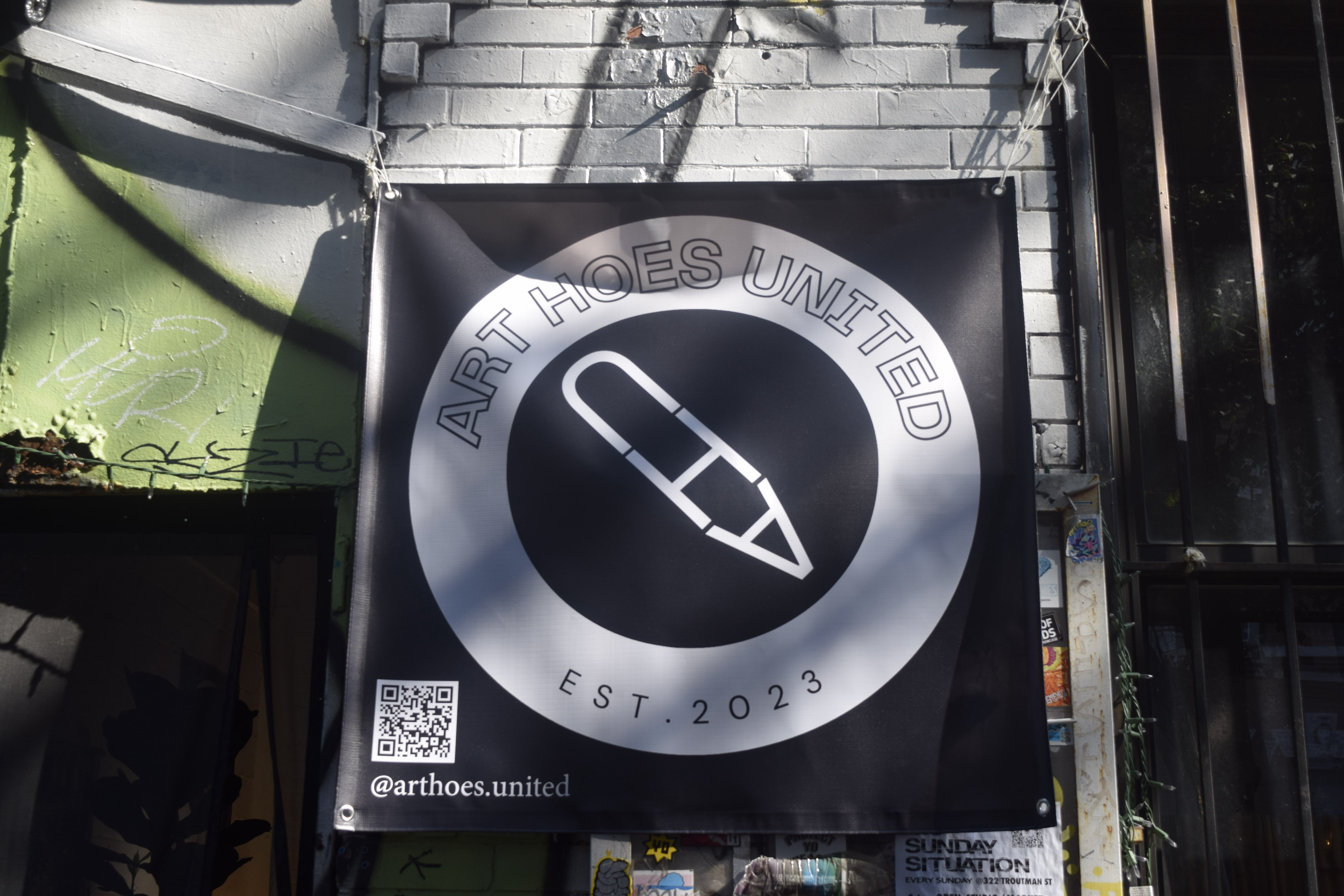 A black and white banner reading 'ART HOES UNITED,' featuring a pencil inside a circle, with 'EST. 2023' and social media handle '@arthoes.united.'