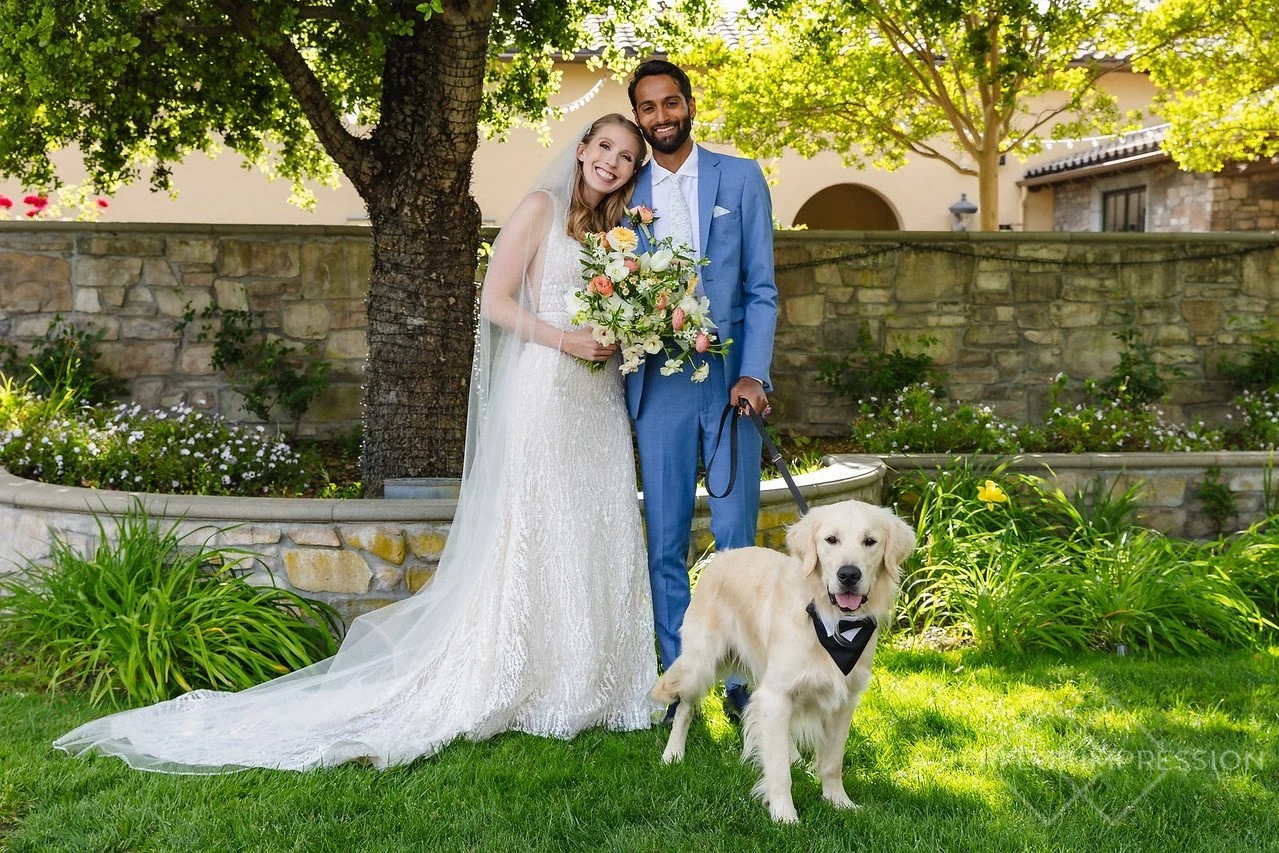 Golden Retriever wearing a tux, posing next to the wedding cocktail napkin featuring his picture